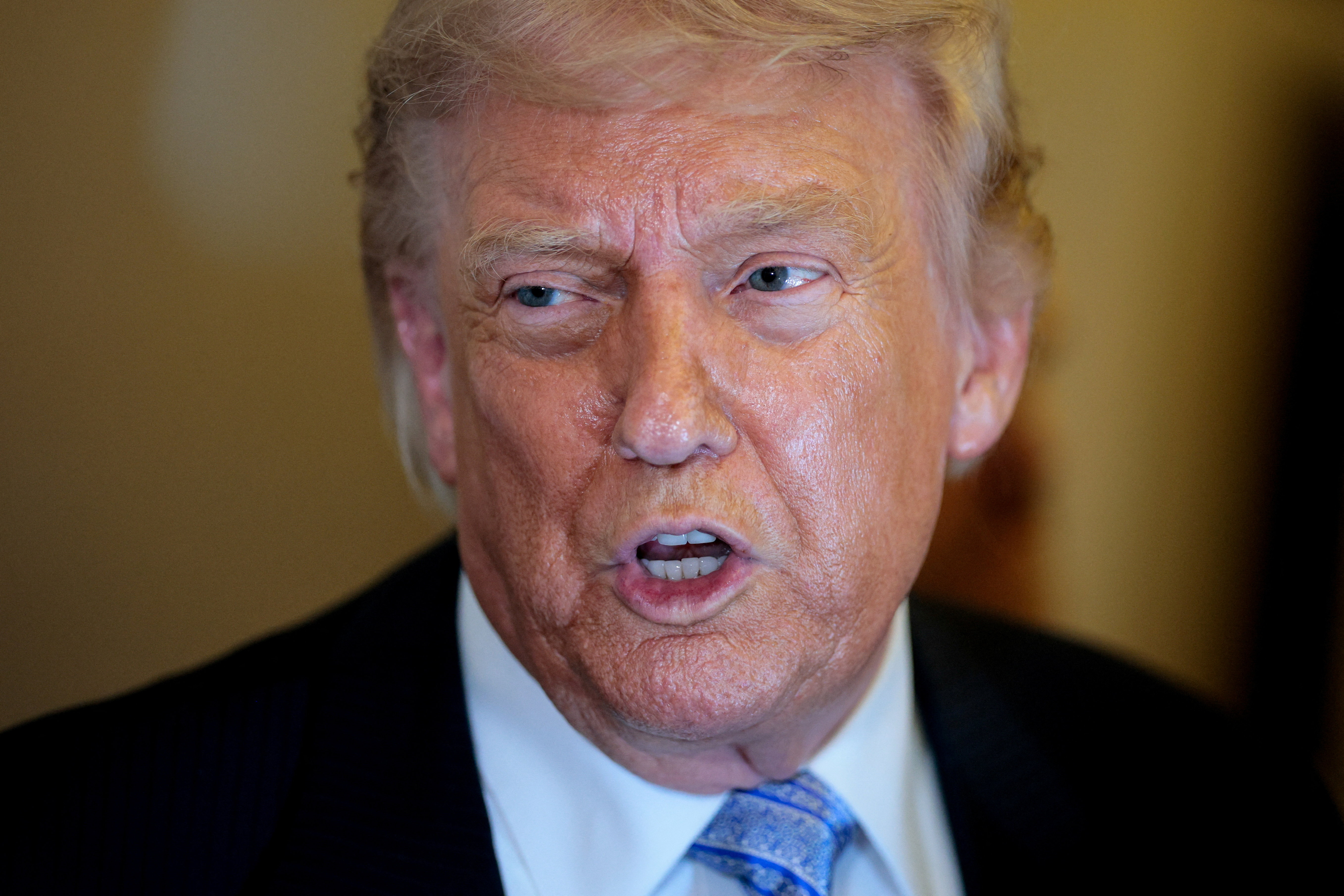 U.S. President Donald Trump speaks to the press aboard Air Force One