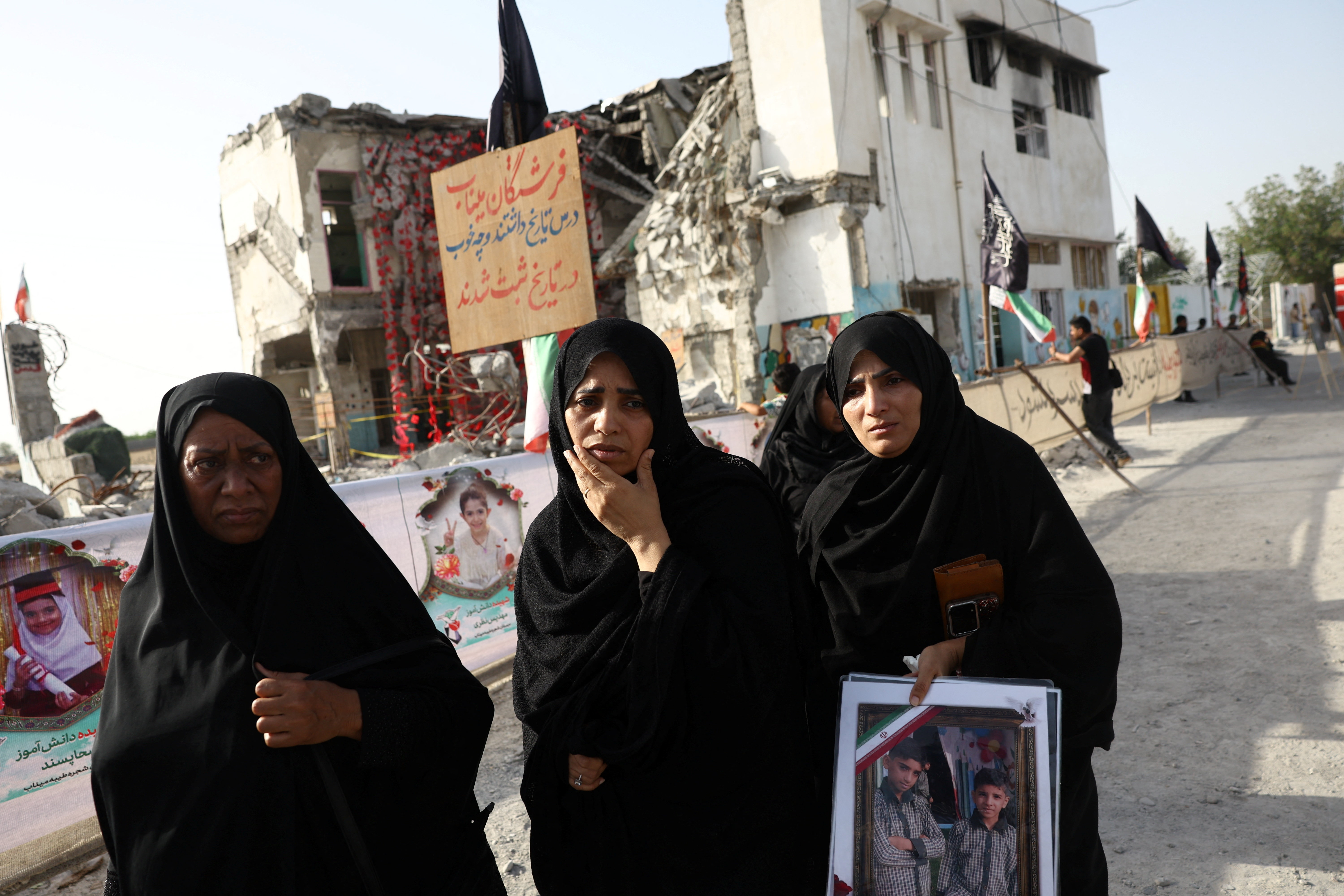 Women stand with a large photo.