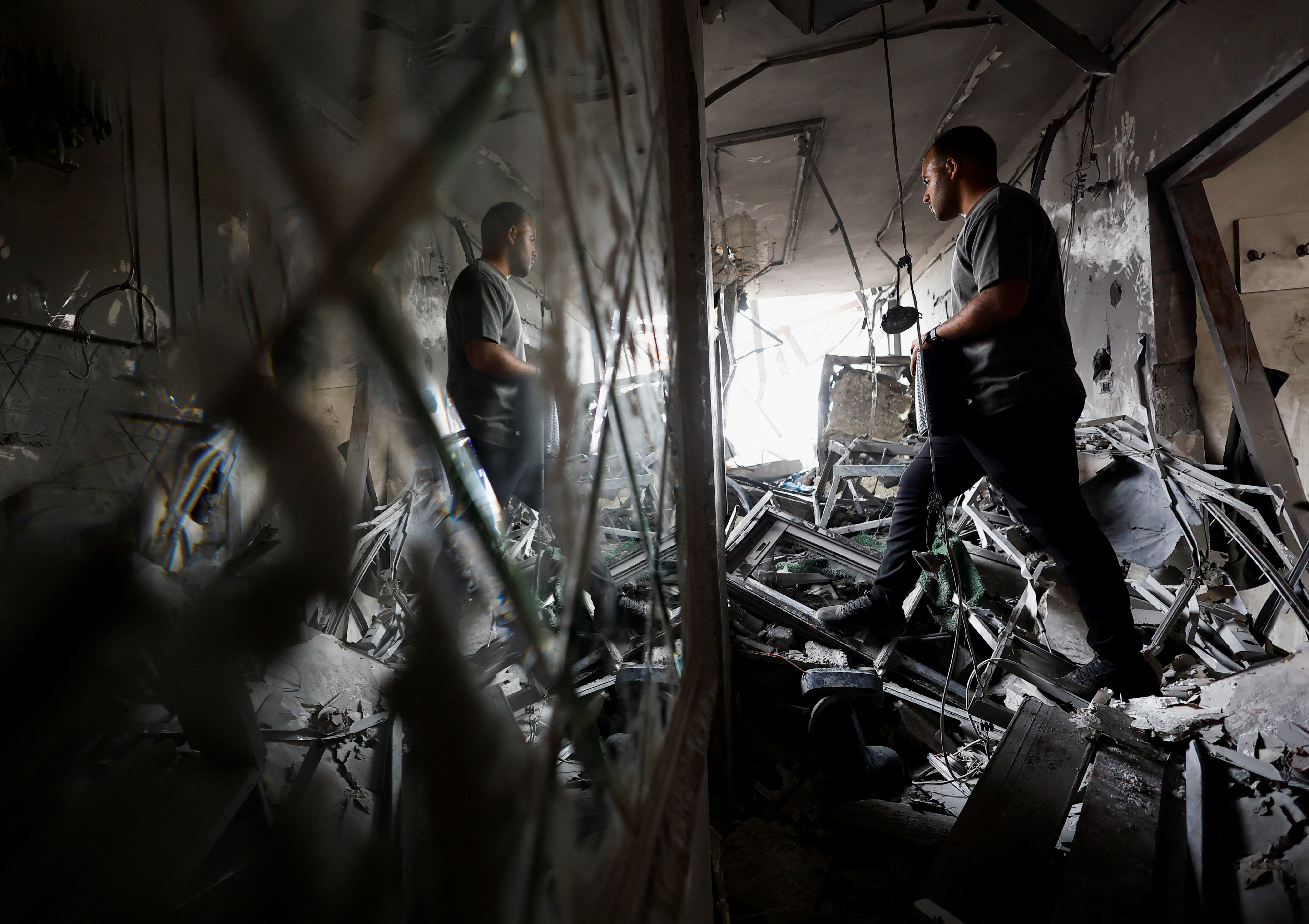 A Palestinian man inspects the site of an Israeli airstrike on a residential building