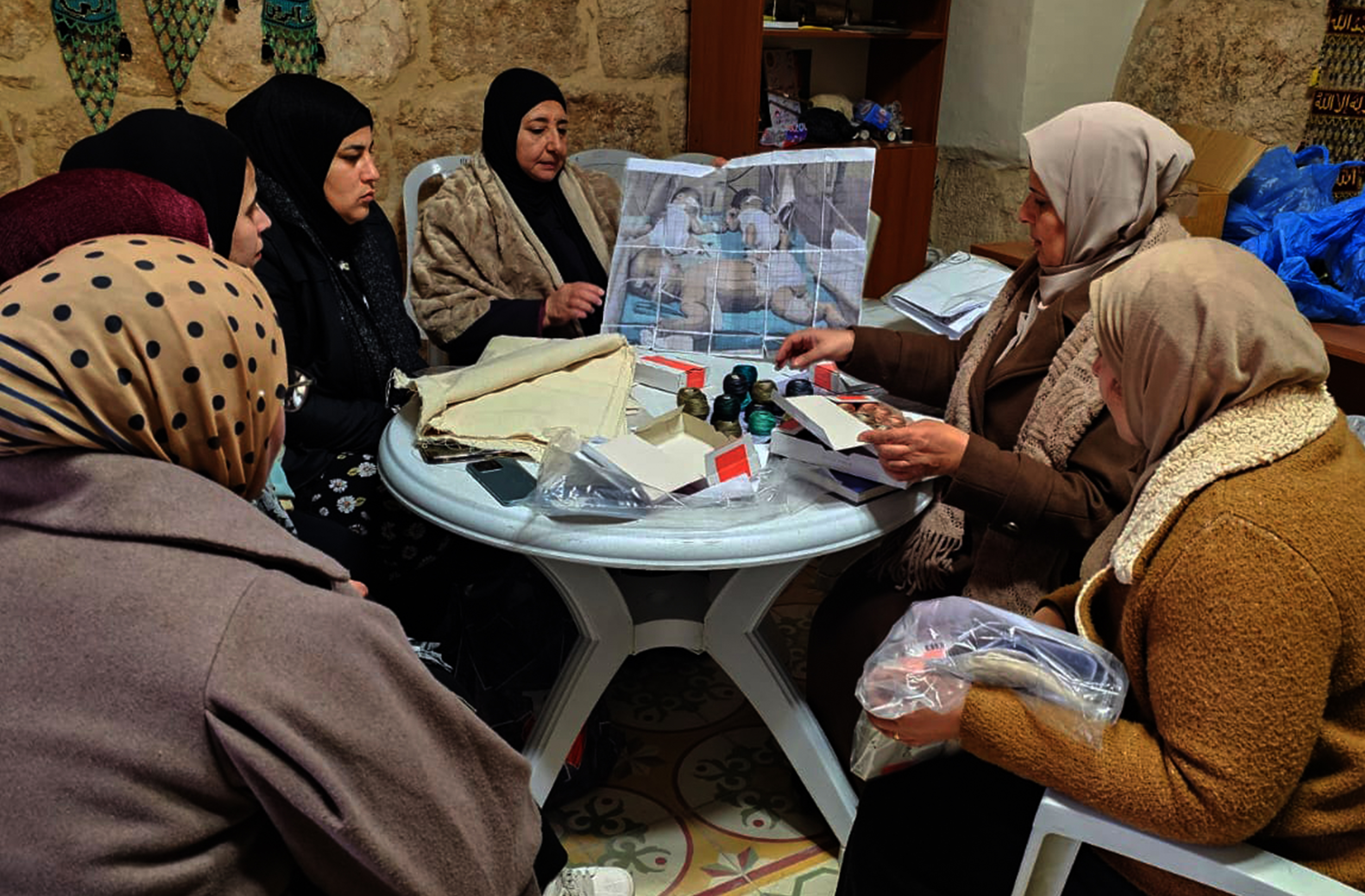 A group of Palestinian embroiderers coneve to perpare panels for stitch. Al-Samou', occupied West Bank. (Courtesy of Palestine Museum US)-1778317102