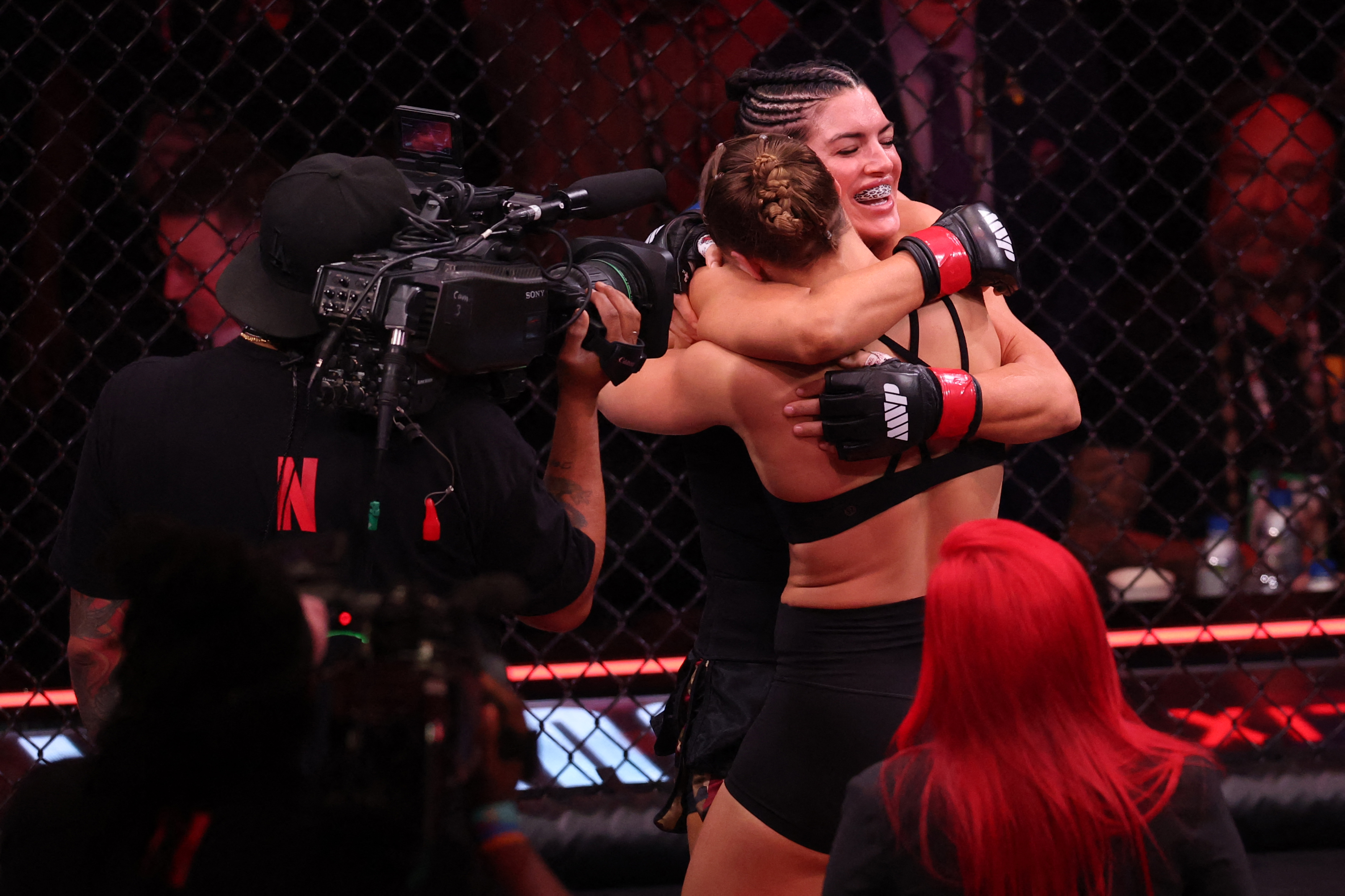 US Mixed Martial Arts (MMA) fighter Ronda Rousey hugs Gina Carano after defeating her during their Featherweight Bout at the Intuit Dome in Inglewood, California, on May 16, 2026. (Photo by Patrick T. Fallon / AFP)
