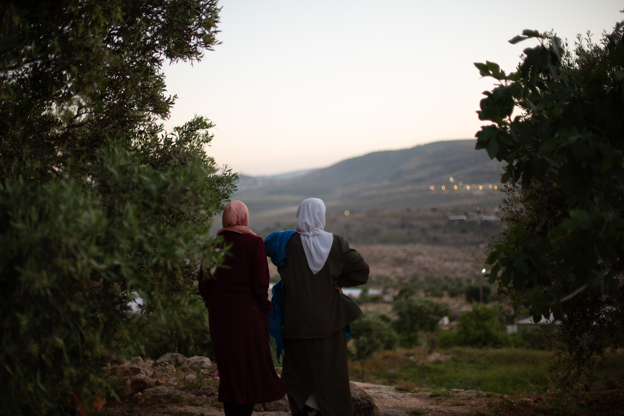 Hajja Latifa and Maysoon Musallam look on as an ATV drives on the small roads near their home