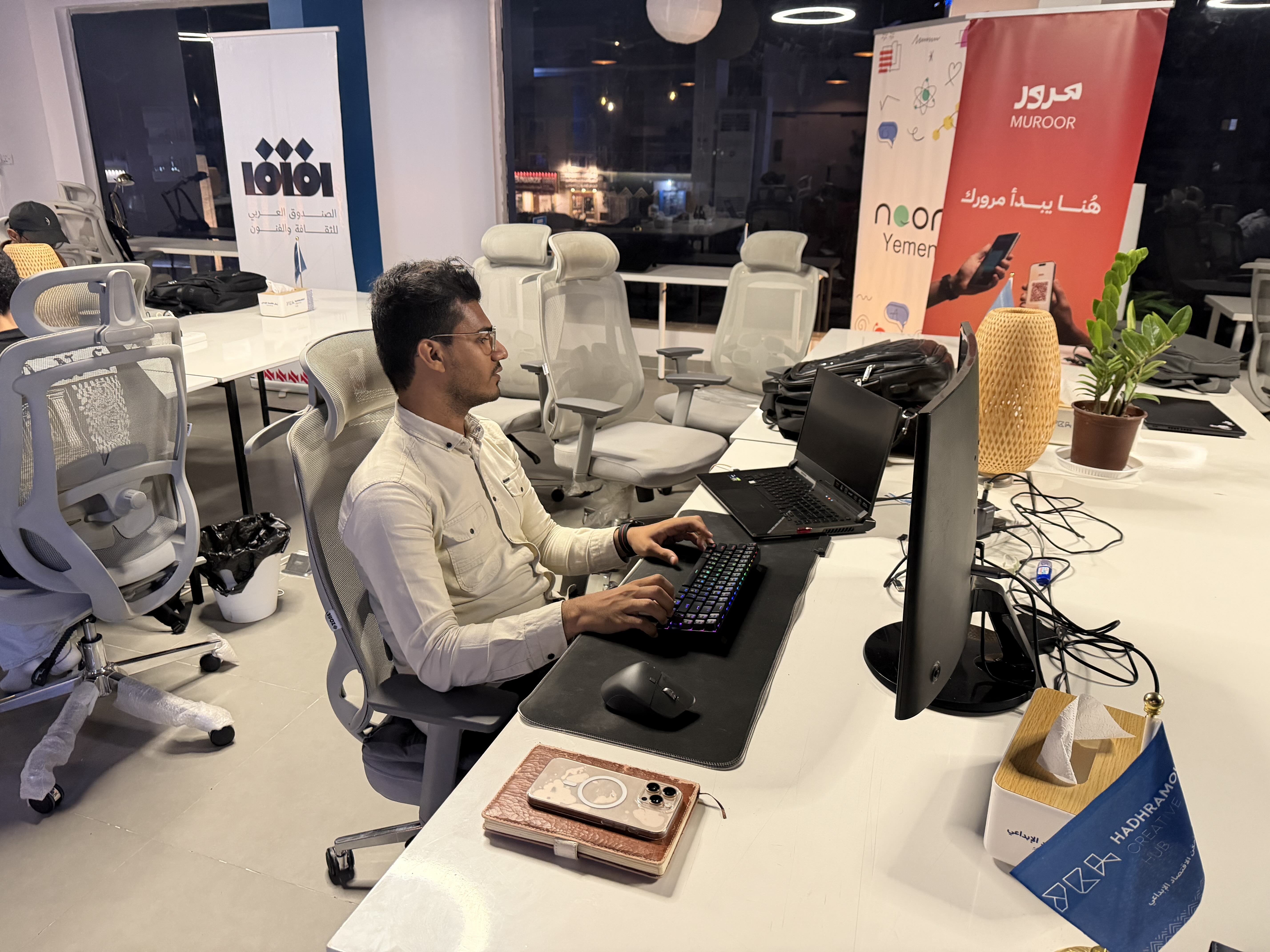 Man sits at desk with computer at cafe