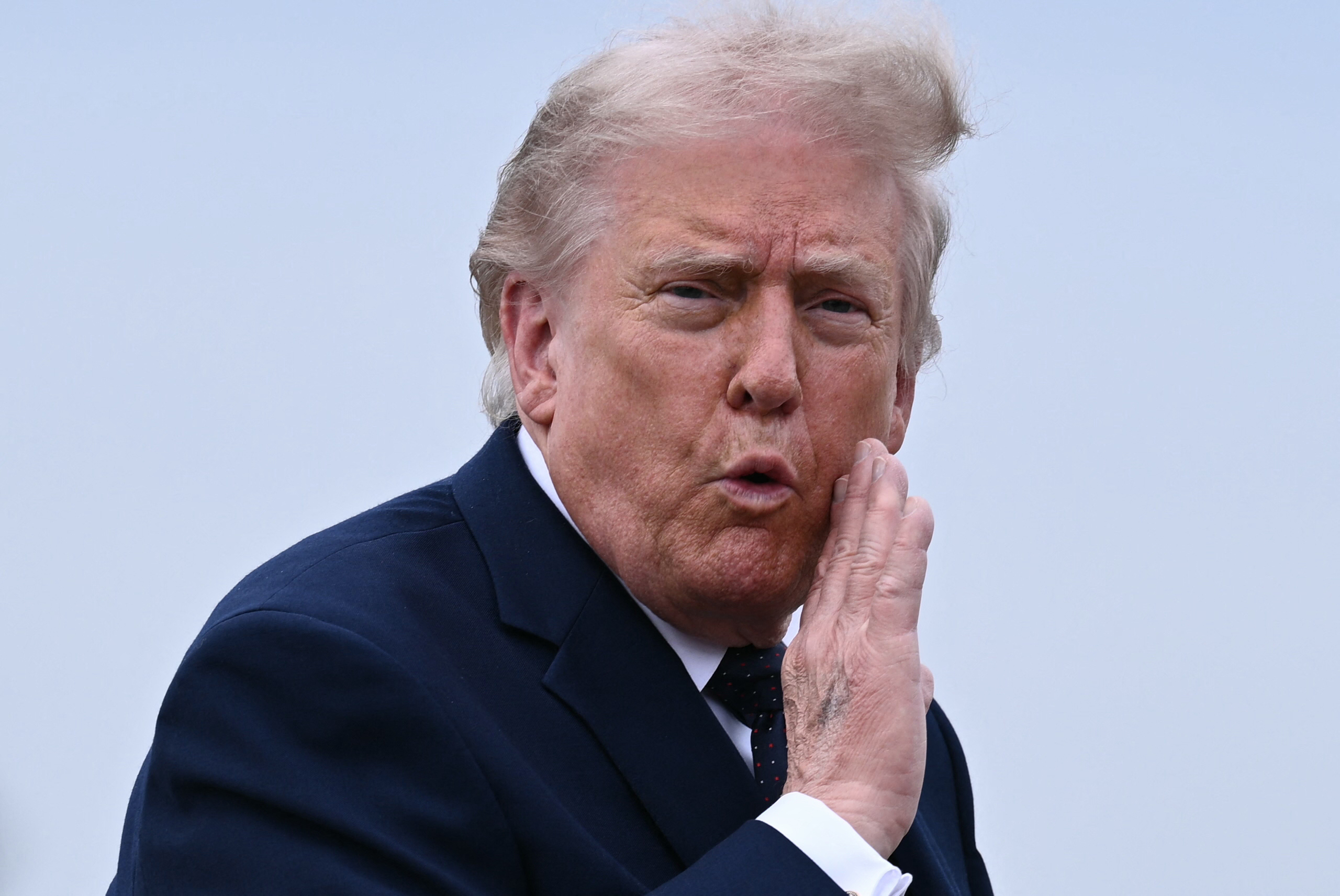 US President Donald Trump gestures as he walks to board a plane at Morristown Airport in Morristown, New Jersey, on May 22, 2026.