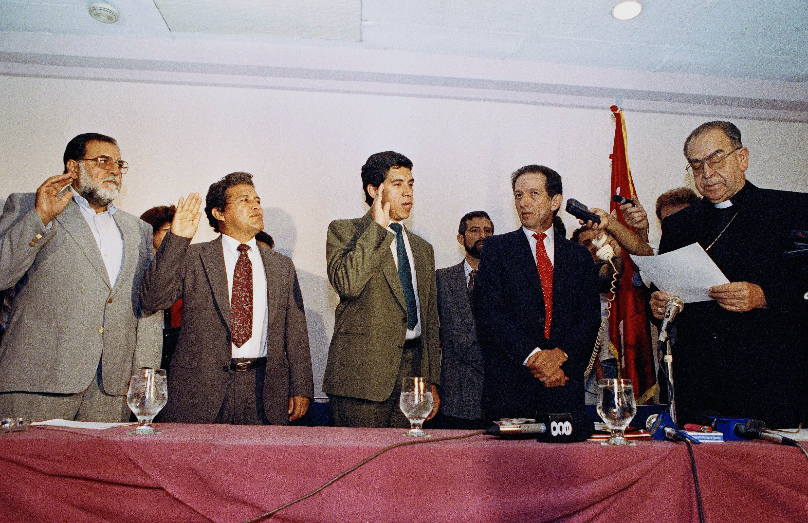 Members of the FMLN, including Schafik Hándal (L), are sworn in by Archbishop Arturo Rivera y Damas in San Salvador in 1992 as the group becomes a political party.