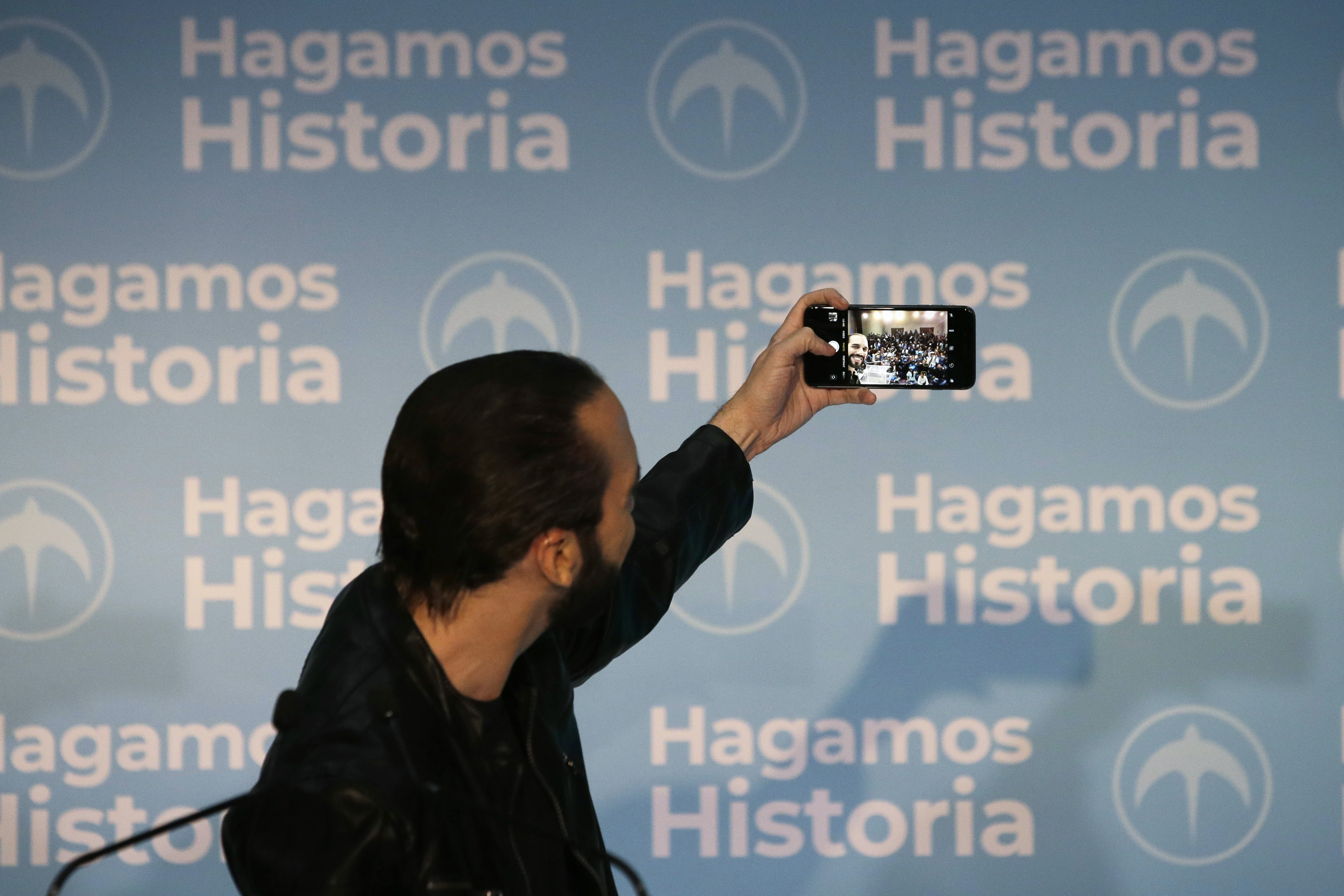 Nayib Bukele takes a selfie during a press conference in San Salvador in 2019, reflecting his preference for communicating directly via social media rather than through traditional media channels.