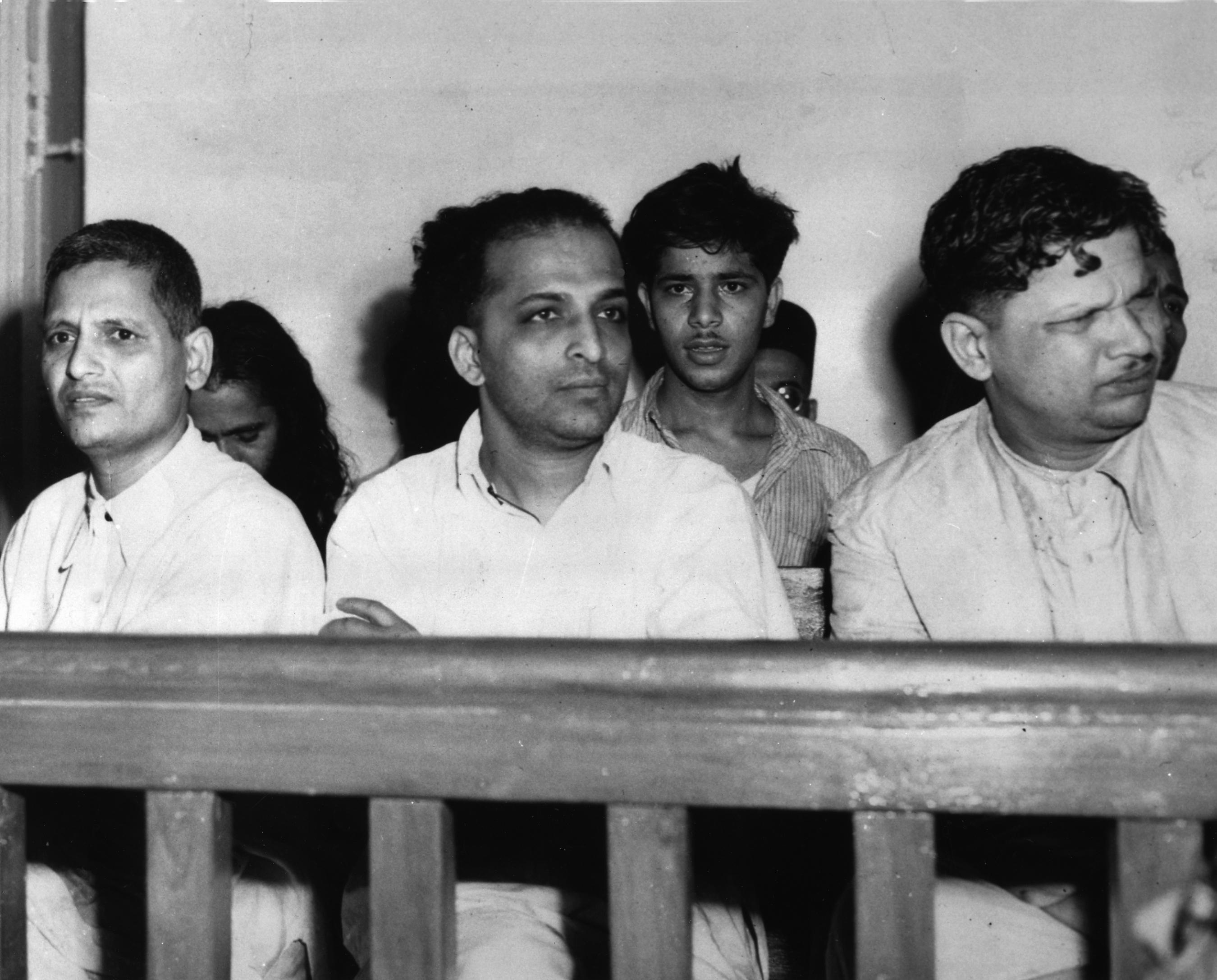 The men accused of the assassination of Mahatma Gandhi listen to testimony in a courtroom during their arraignment in New Delhi, India, on May 27, 1948. Gandhi was shot three times by Nathuram Vinayak Godse, center, on his way to a prayer meeting from Birla House on Jan. 30. At left is Narayan Dattraya Apte and at right is Vishnu Ramkrishna Karkare. In second row at center is Madan Lal, accused of exploding a bomb on Jan. 20 outside a Gandhi prayer meeting at Birla House. (AP Photo)