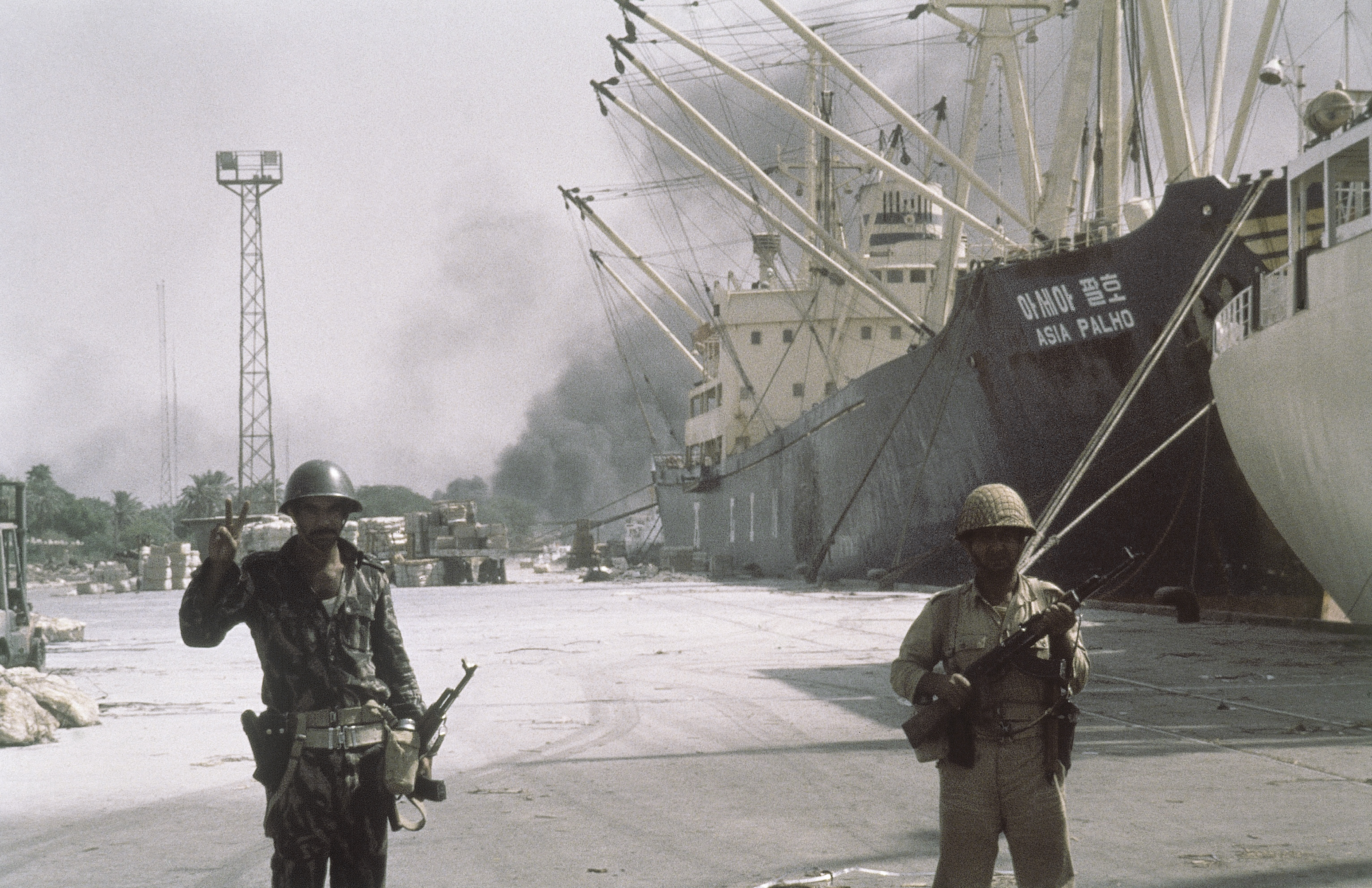 Iraqi forward troops stand guard over shipping at the dockside in occupied Khorramshahr, Iran on Oct. 7, 1980. (AP Photo)