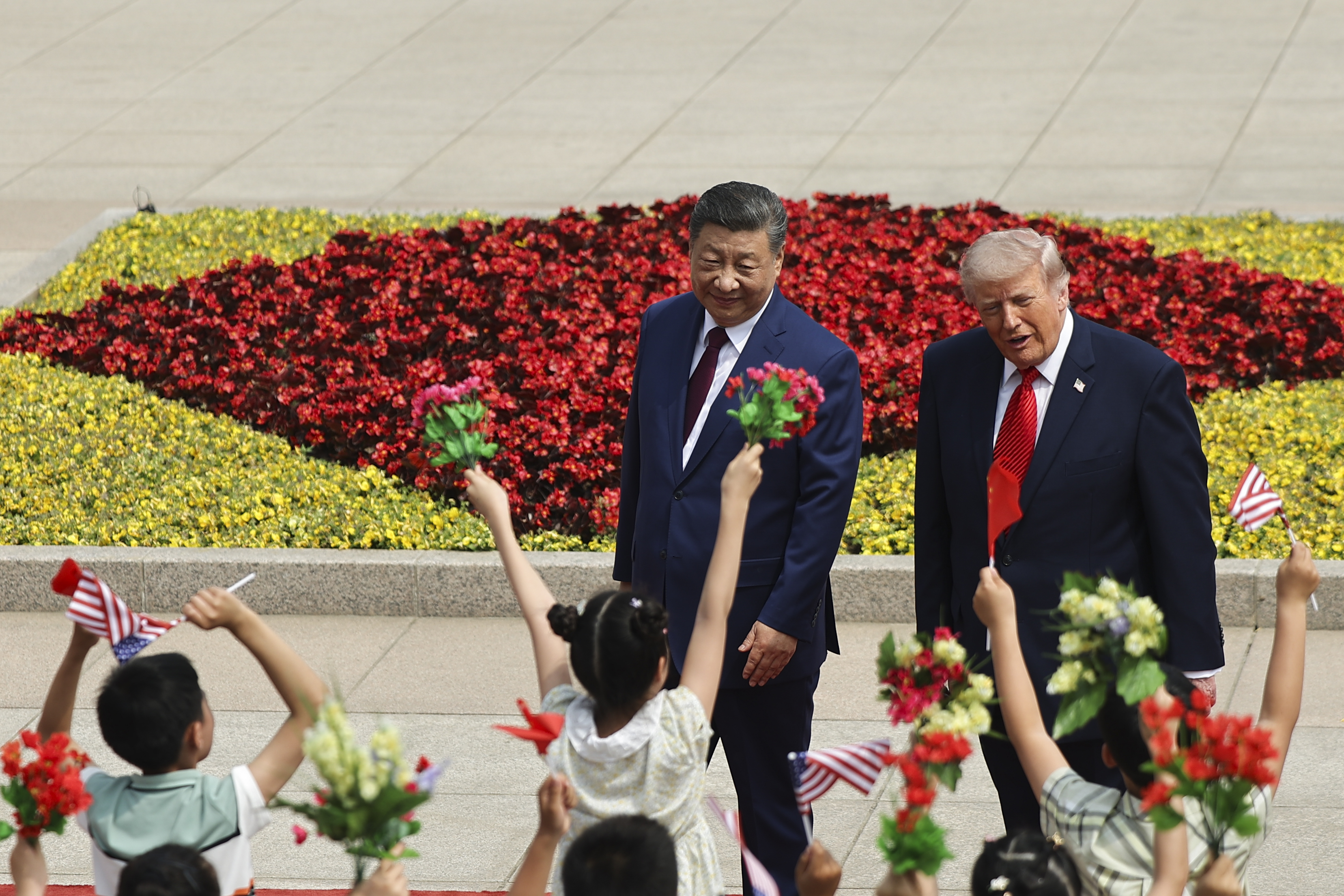 epa12955678 Children hold Chinese and U.S. flags as U.S. President Donald Trump participates in a welcome ceremony with Chinese President Xi Jinping at the Great Hall of the People in Beijing, China, 14 May 2026. EPA/Maxim Shemetov / POOL