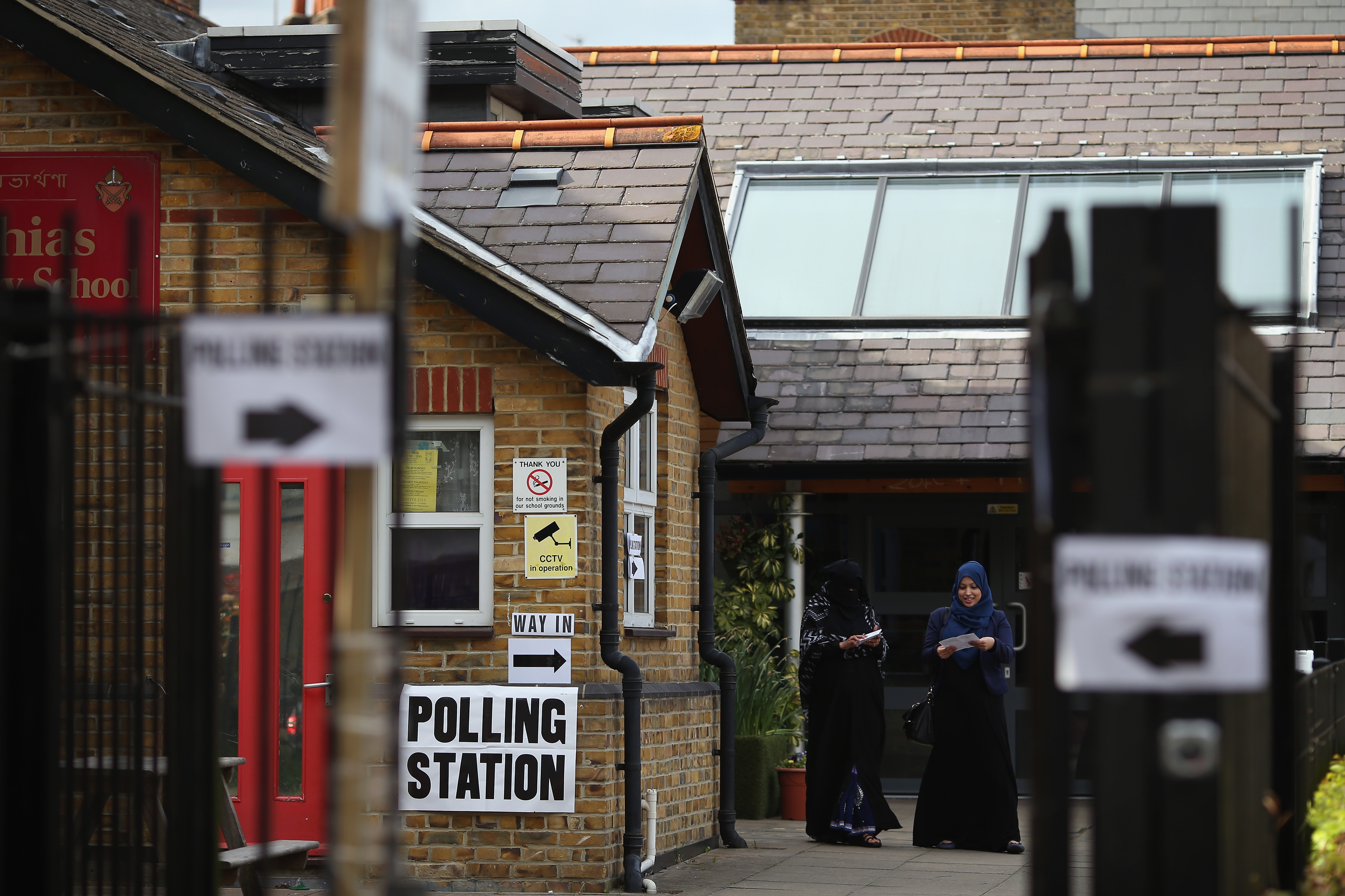 LONDON, UNITED KINGDOM - MAY 07: Muslim women leave a polling station near Brick Lane after casting their vote on May 7, 2015 in London, England. The United Kingdom has gone to the polls to vote for a new government in one of the most closely fought General Elections in recent history. With the result too close to call it is anticipated that there will be no overall clear majority winner and a coalition government will have to be formed once again. (Photo by Dan Kitwood/Getty Images)