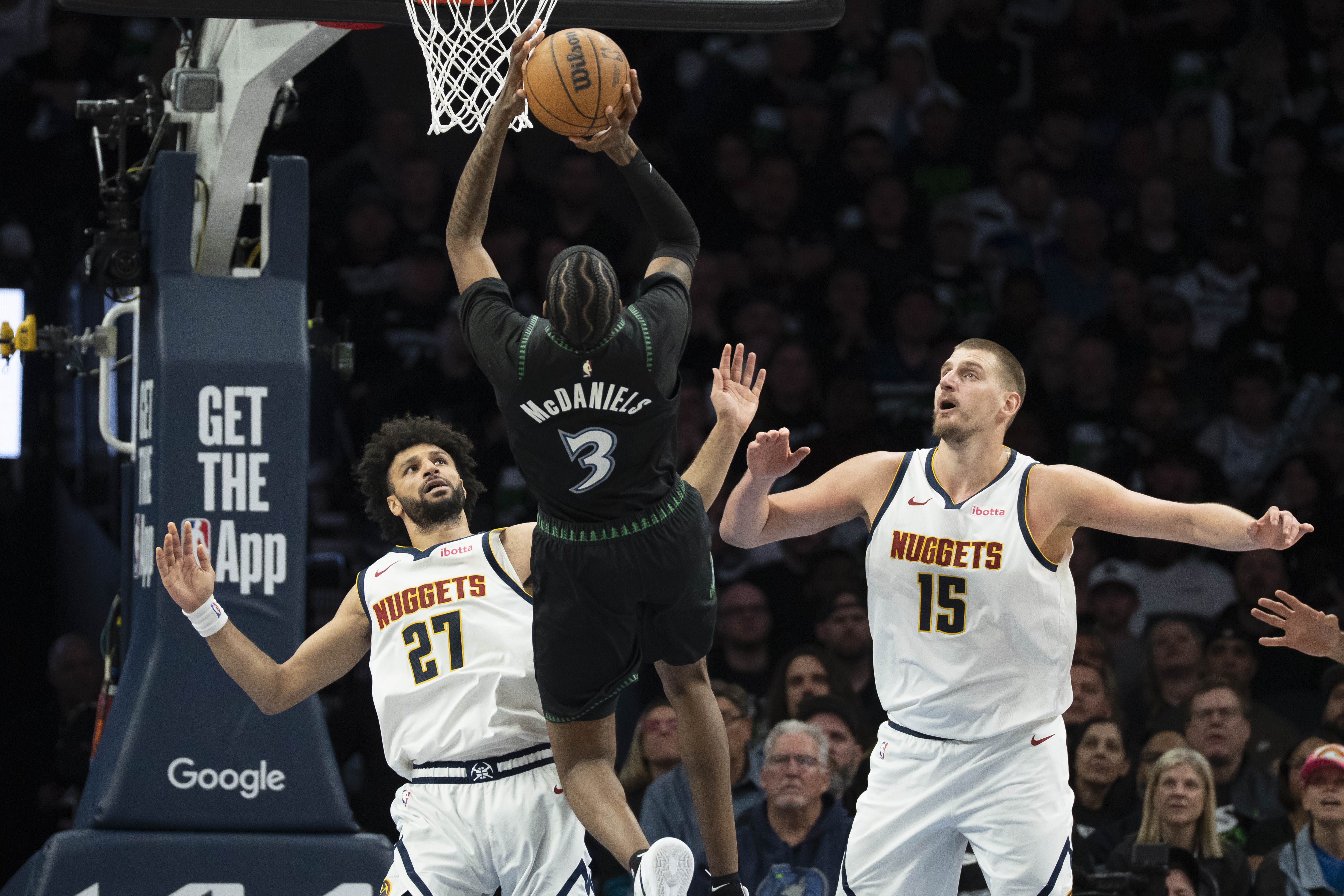 Minnesota Timberwolves forward Jaden McDaniels (3) shoots the ball over Denver Nuggets guard Jamal Murray (27)