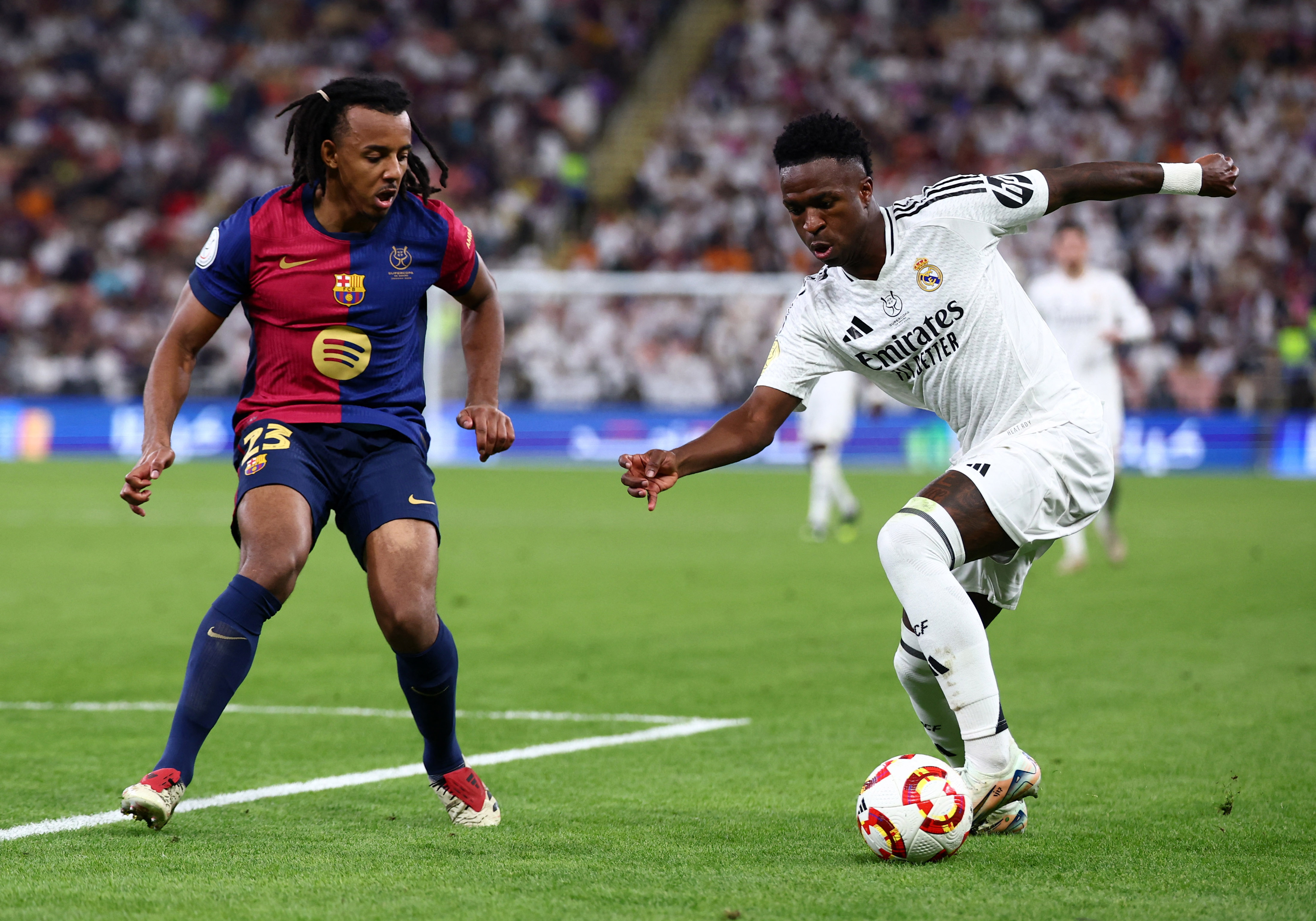 Real Madrid's Vinicius Junior in action with FC Barcelona's Jules Kounde.