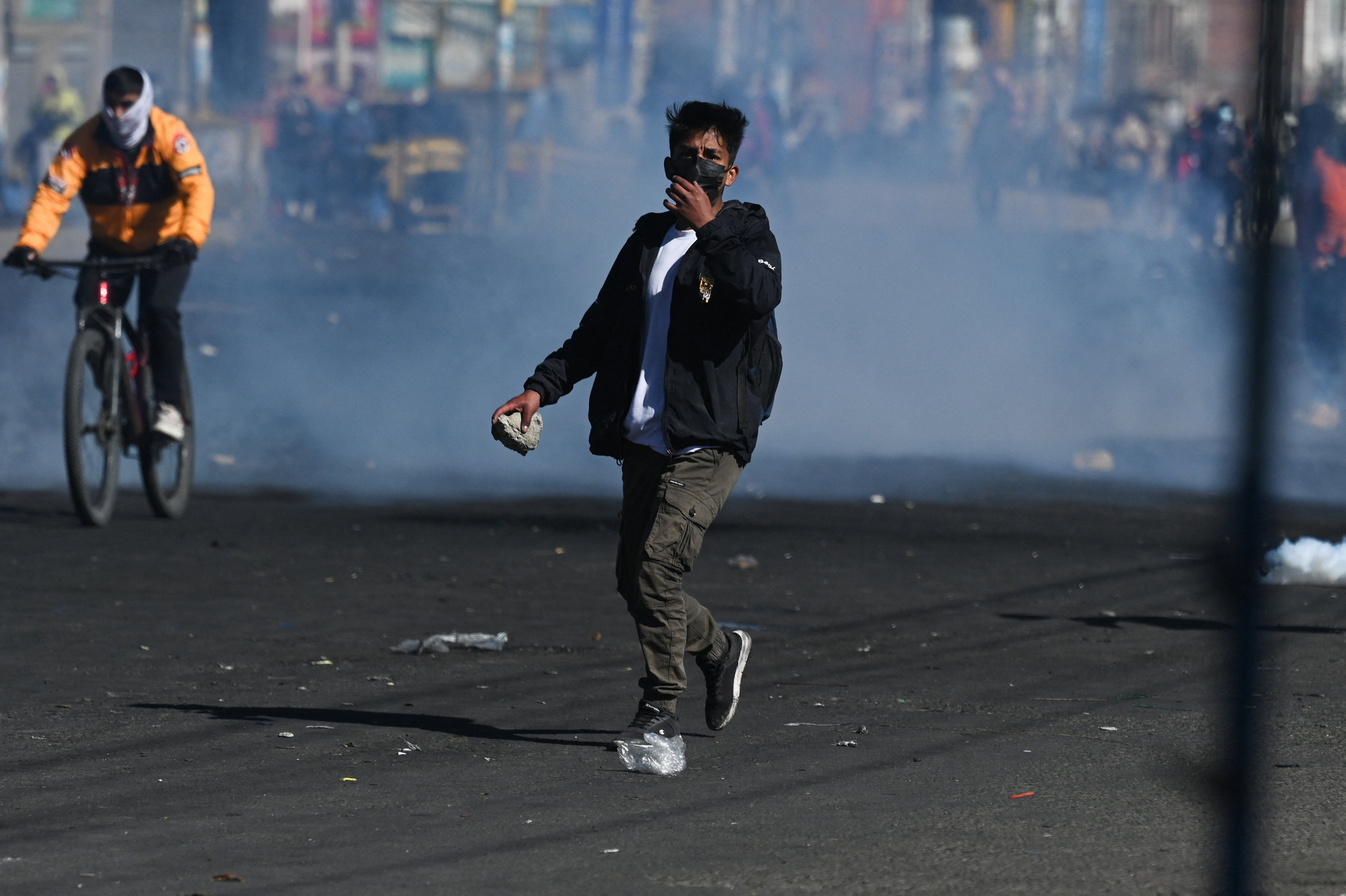 A demonstrator wearing a face mask holds a rock as tear gas spreads behind him during a protest against President Rodrigo Paz's government amid an ongoing economic and fuel crisis in El Alto, Bolivia, May 16, 2026. REUTERS/Claudia Morales