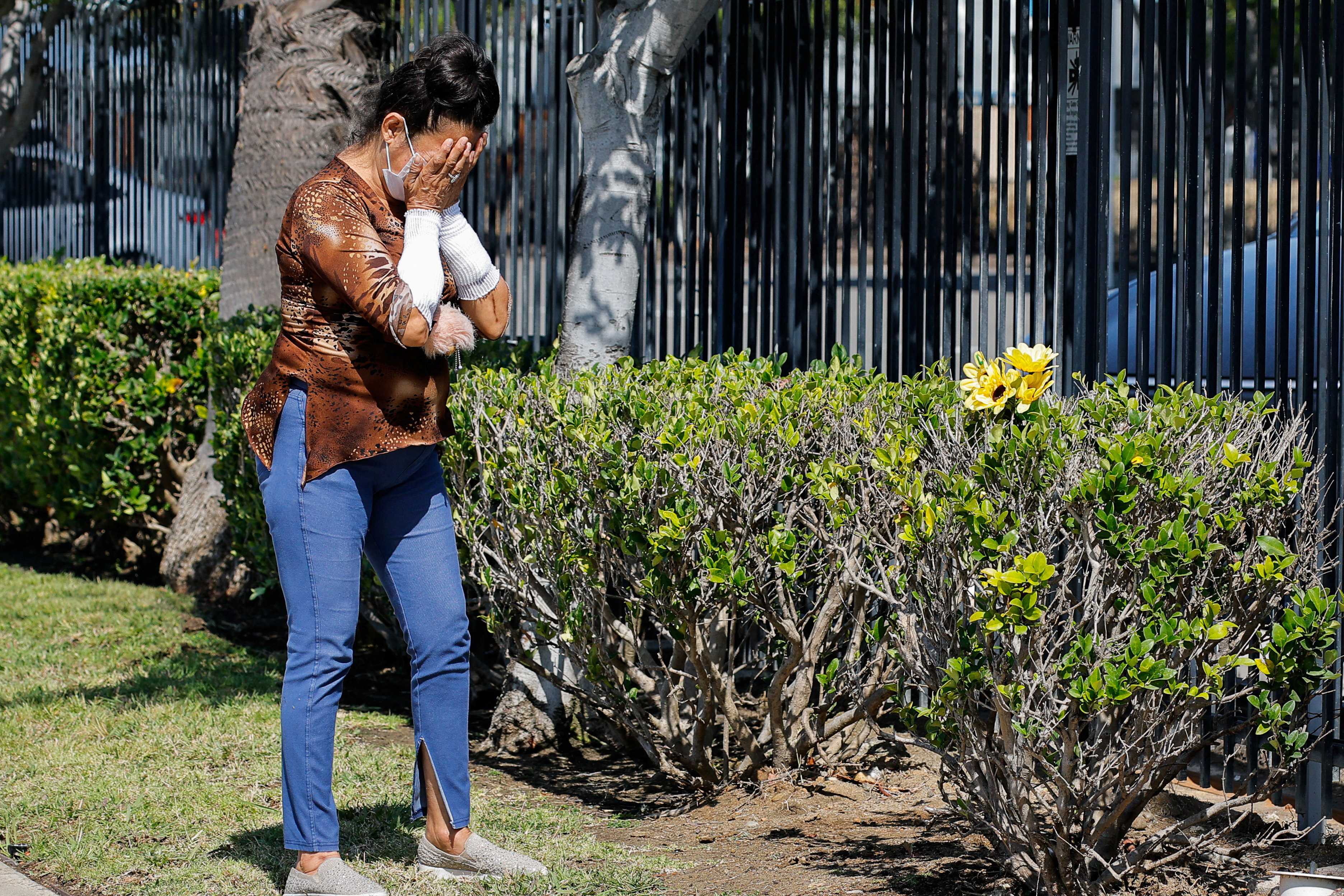 A woman reacts, after leaving flowers to pay her respects, outside the Islamic Centre of San Diego, the morning following a shooting, in San Diego, California, U.S, May 19, 2026. REUTERS/ Mike Blake