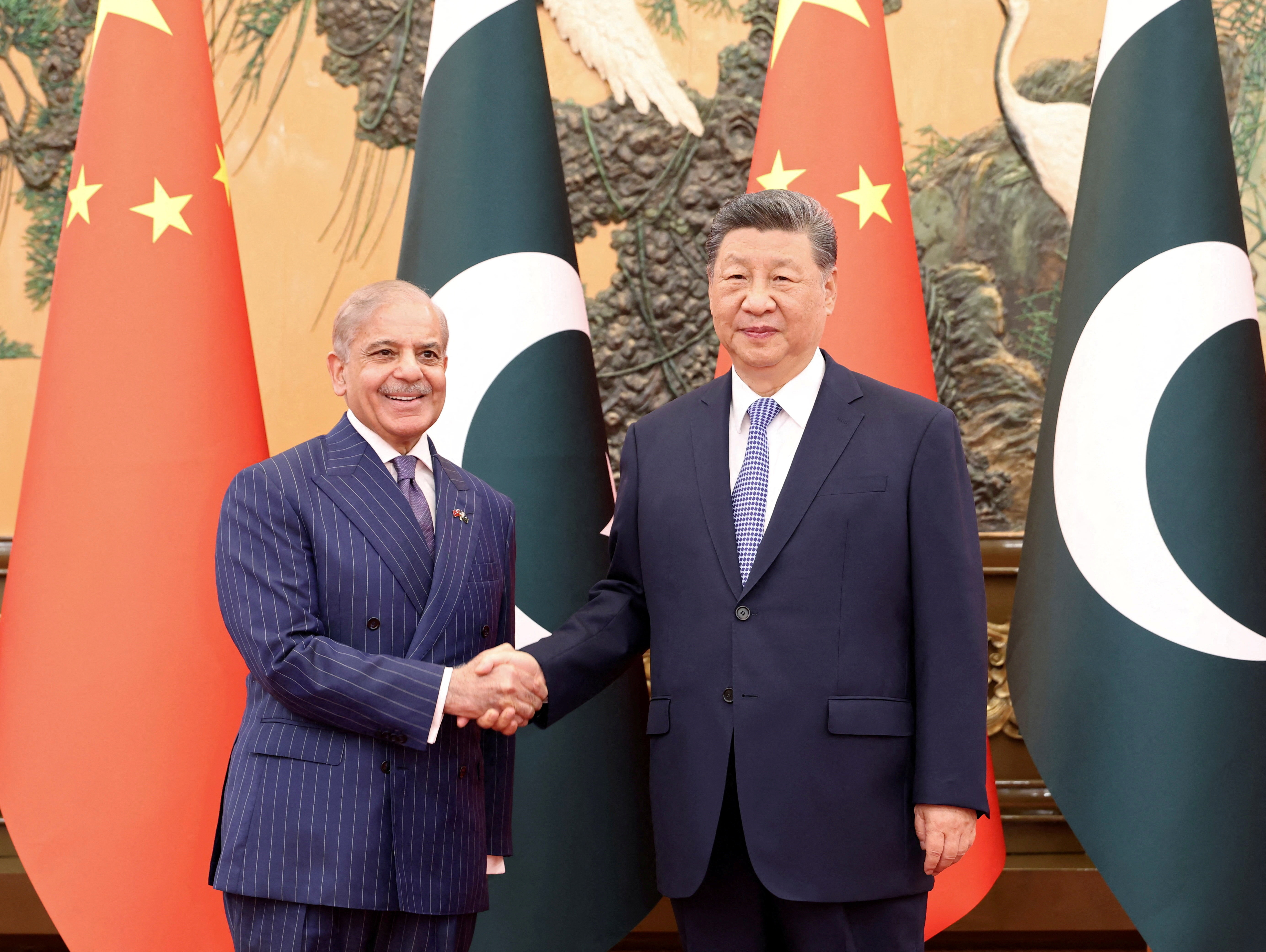 Chinese President Xi Jinping and Pakistani Prime Minister Shehbaz Sharif shake hands at the Great Hall of the People in Beijing
