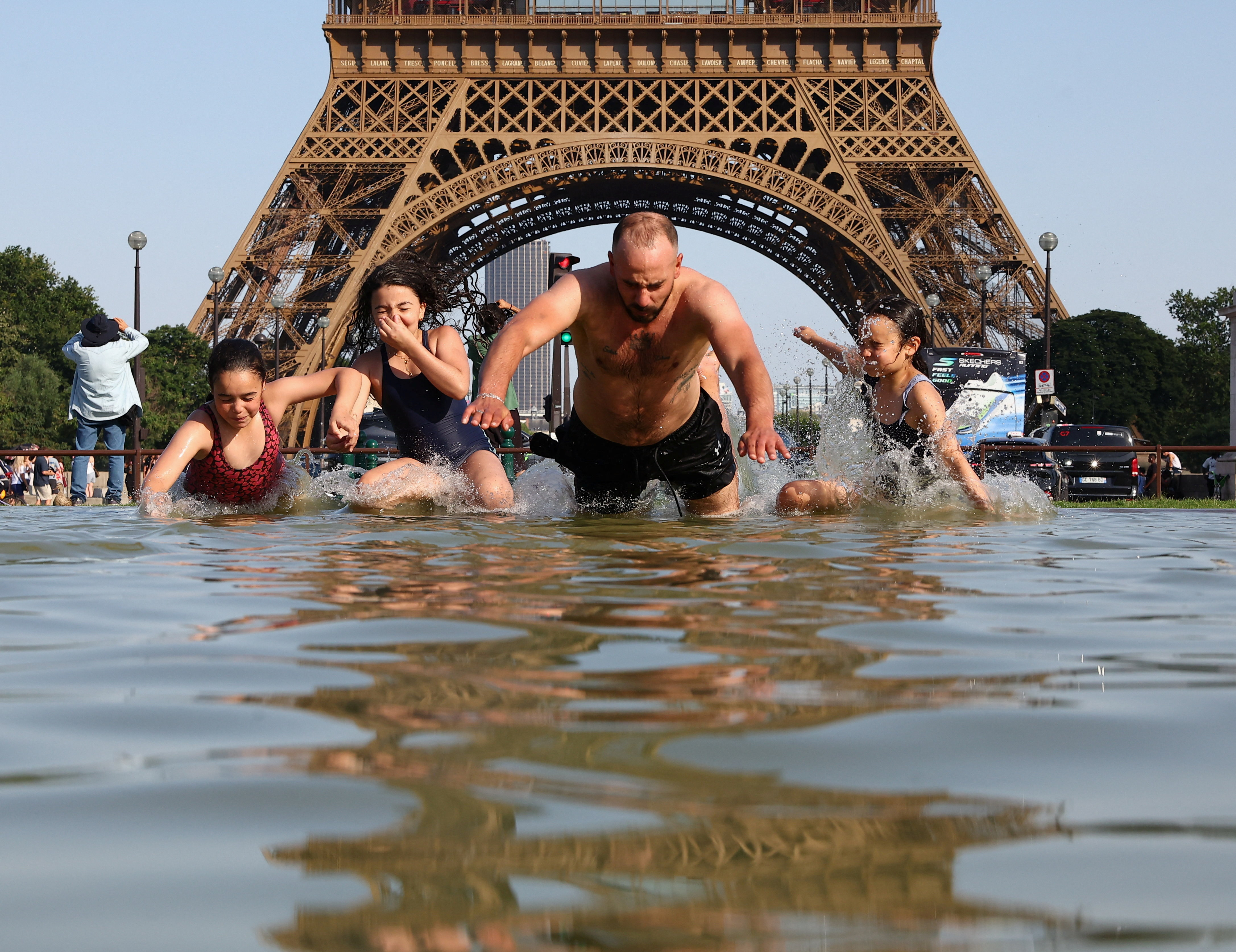 People cool off in the Trocadero Fountain next to the Eiffel Tower as temperatures rise during a heatwave affecting a large part of the country, in Paris, June 22, 2026 [Abdul Saboor/Reuters]