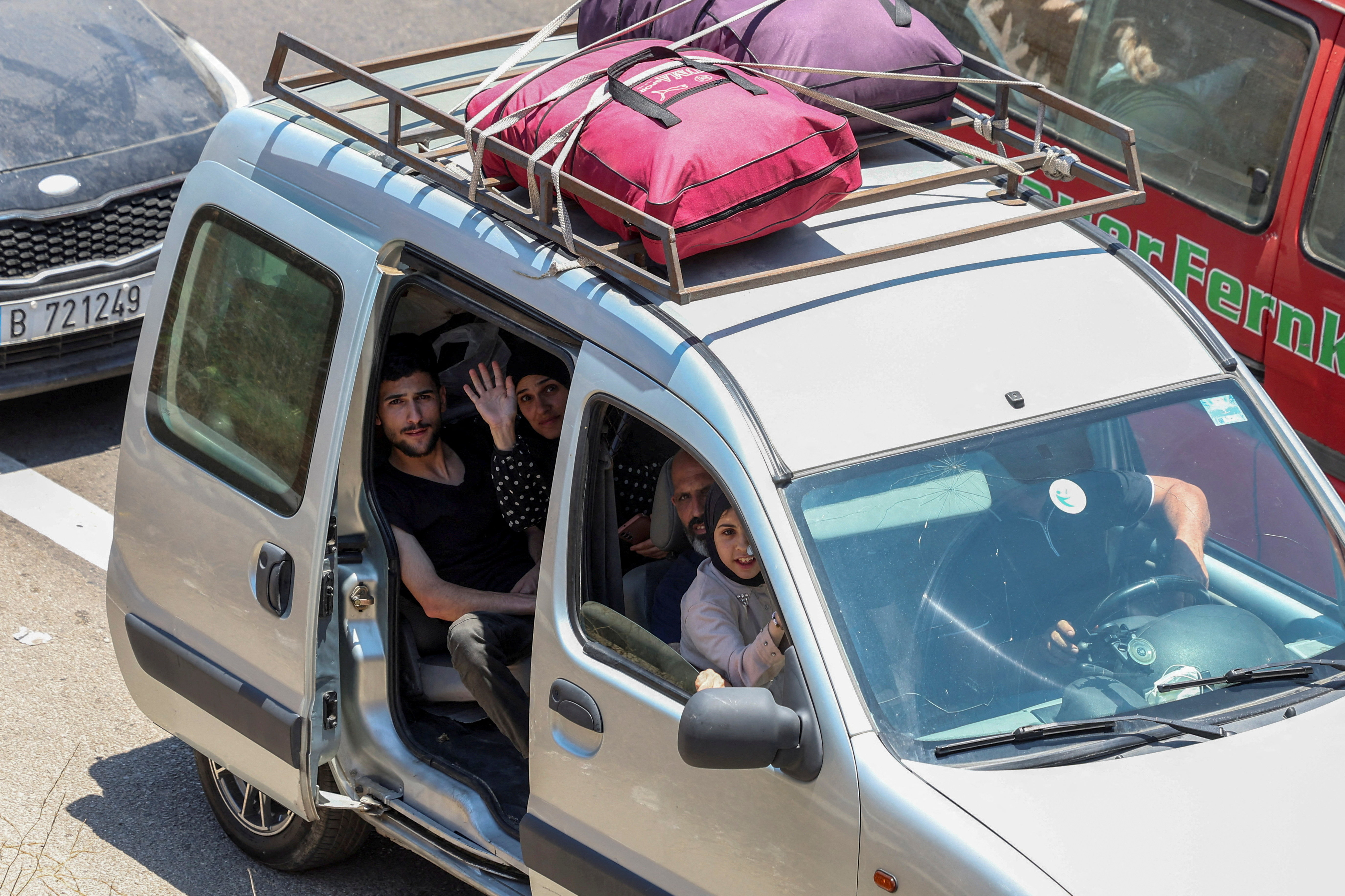 People in a vehicle with their belongings.