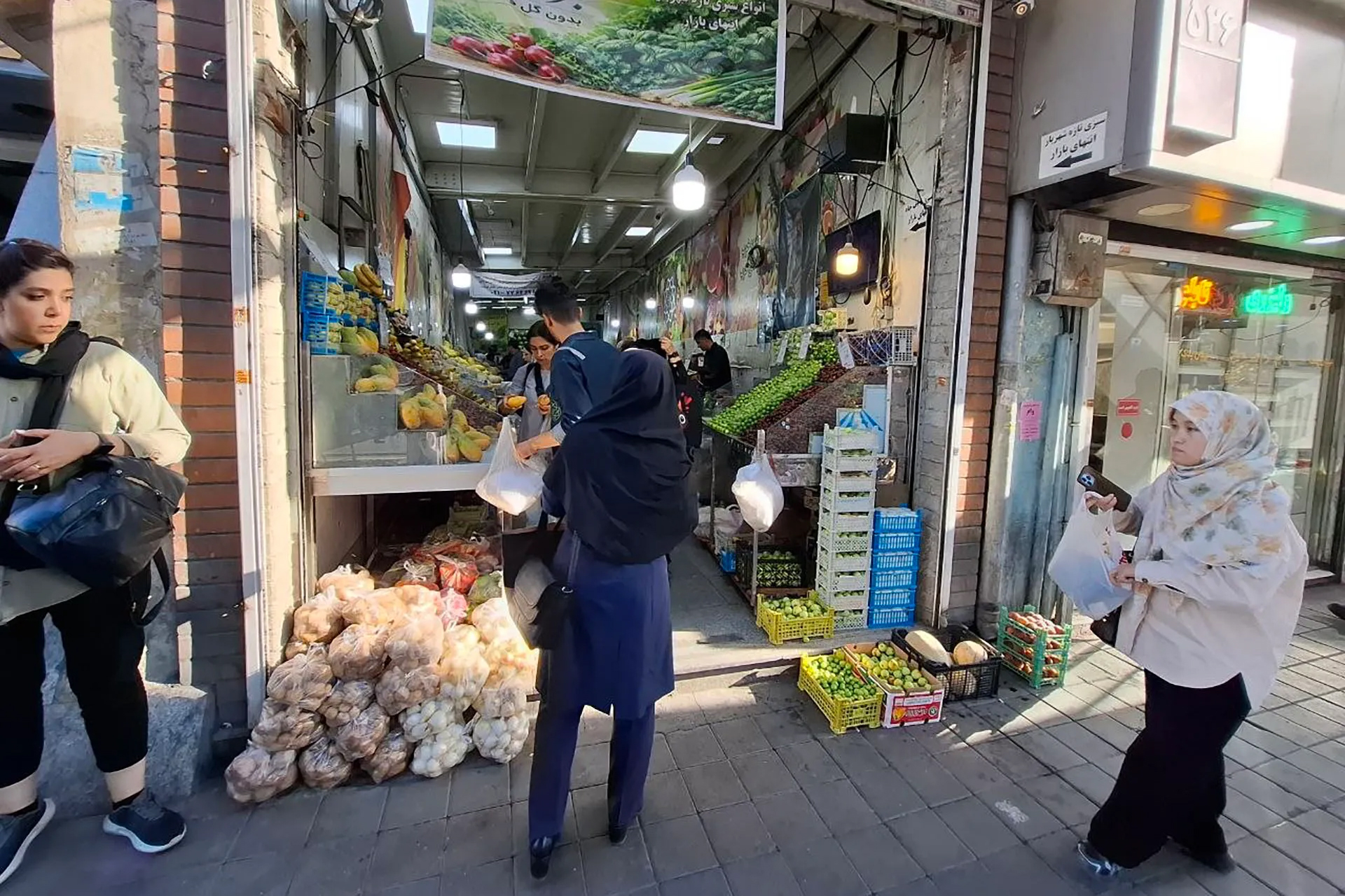 Shoppers browse for fresh produce at a market in Tehran. Consumers report that despite the rial’s recovery, prices for basic food items and other necessities remain stubbornly high