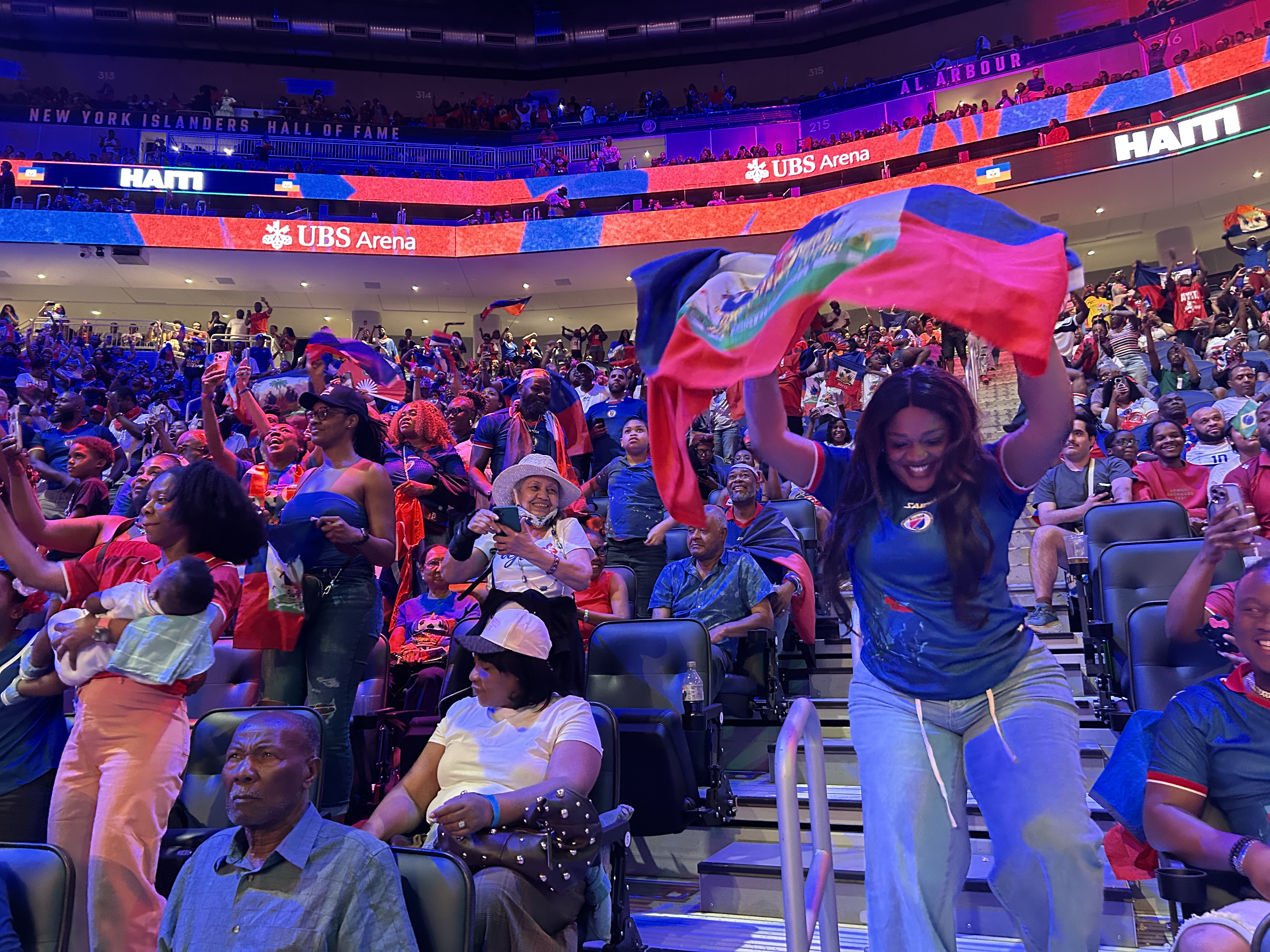 Haitian supporters cheering on their team despite a 3-0 deficit against Brazil at halftime, at the UBS Arena watchparty in Elmont, New York [Lauren Ong/Al Jazeeta]