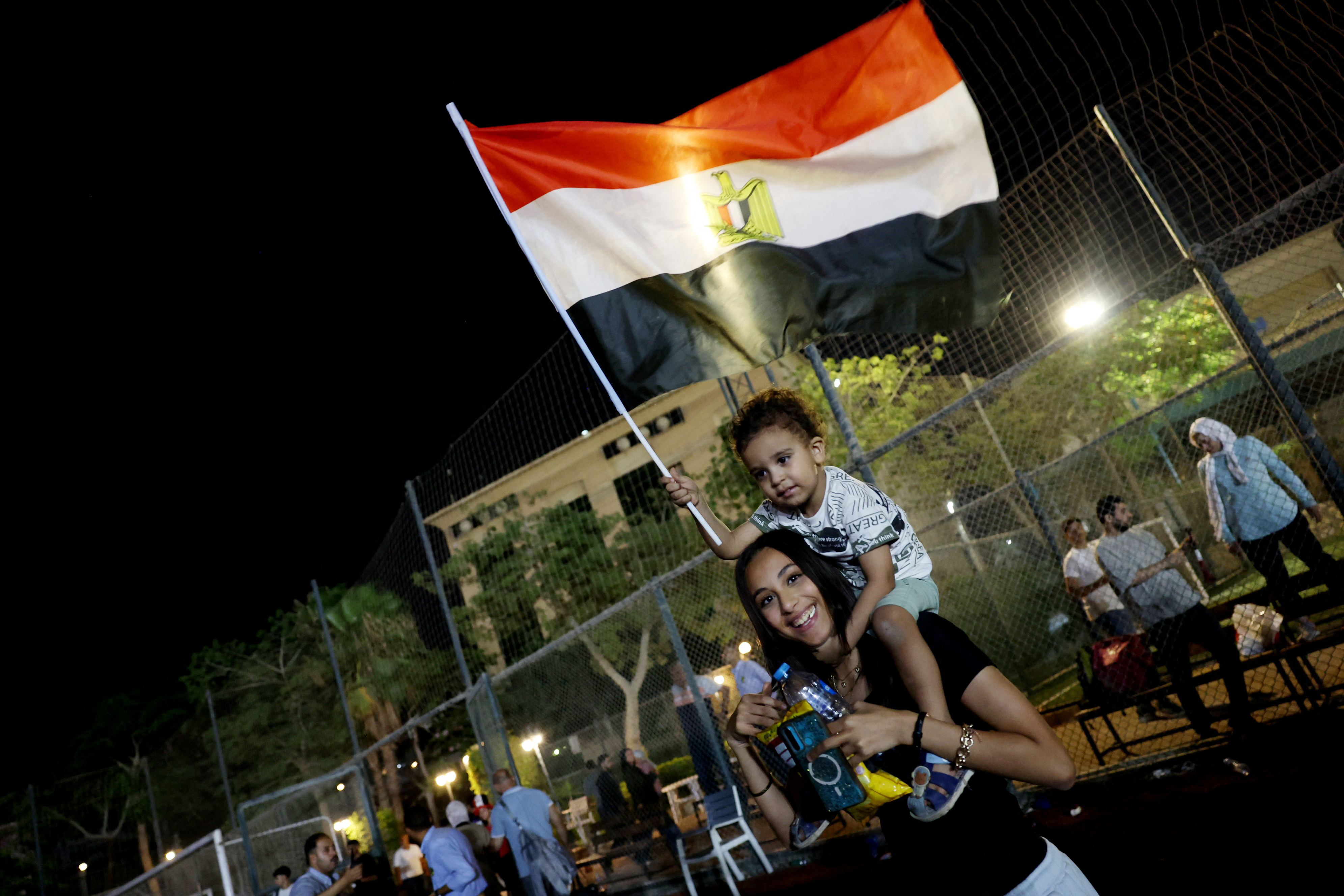 Soccer Football - FIFA World Cup 2026 - Round of 32 - Australia v Egypt - Fans gather in Cairo - Cairo, Egypt - July 3, 2026 An Egypt fan carries a child waving an Egyptian flag as they gather in Cairo to watch the match REUTERS/Amr Abdallah Dalsh