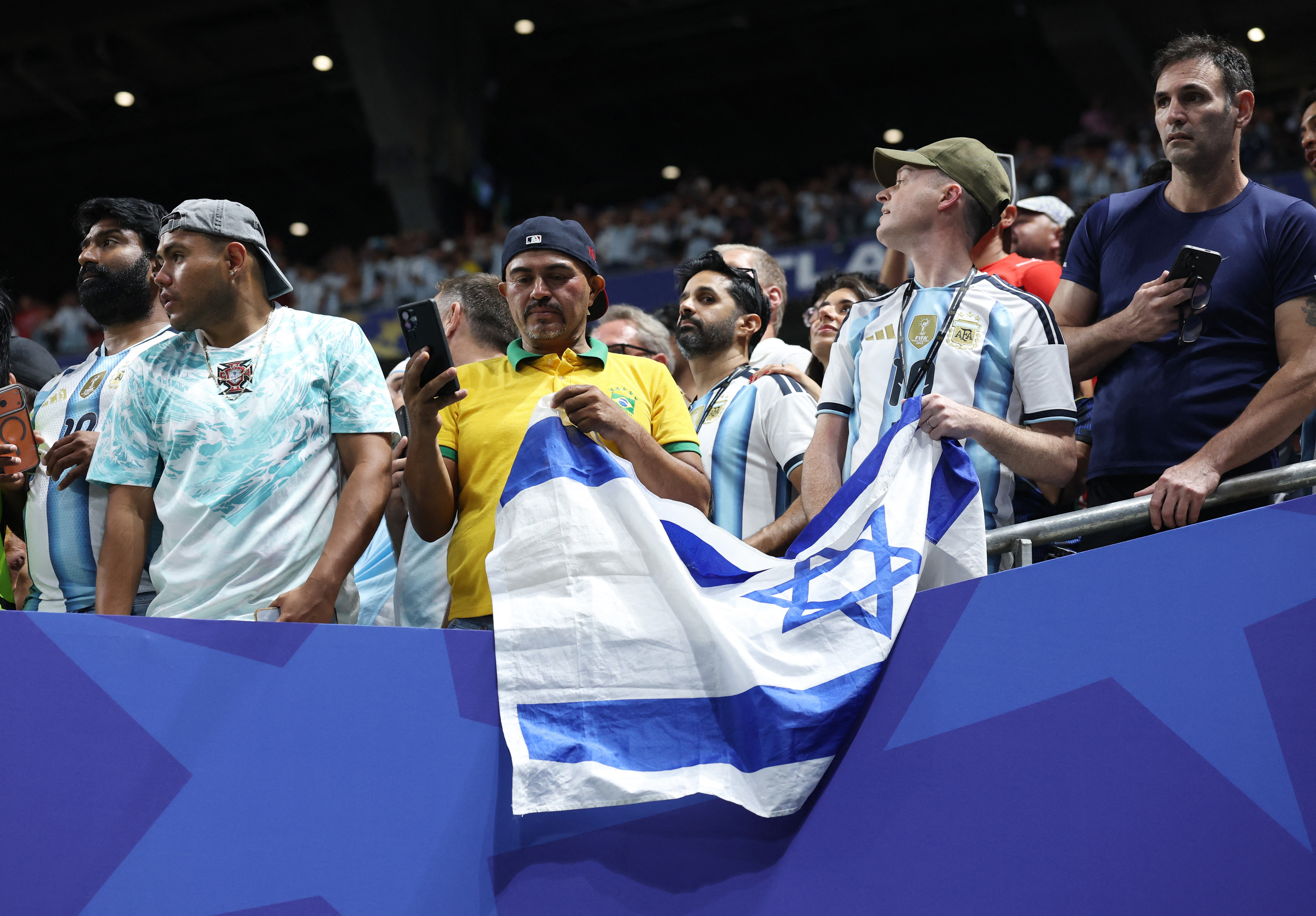 Soccer Football - FIFA World Cup 2026 - Round of 16 - Argentina v Egypt - Atlanta Stadium, Atlanta, Georgia, U.S. - July 7, 2026 An Argentina and Brazil fan with an Israel flag in the stands after the match REUTERS/Paul Childs