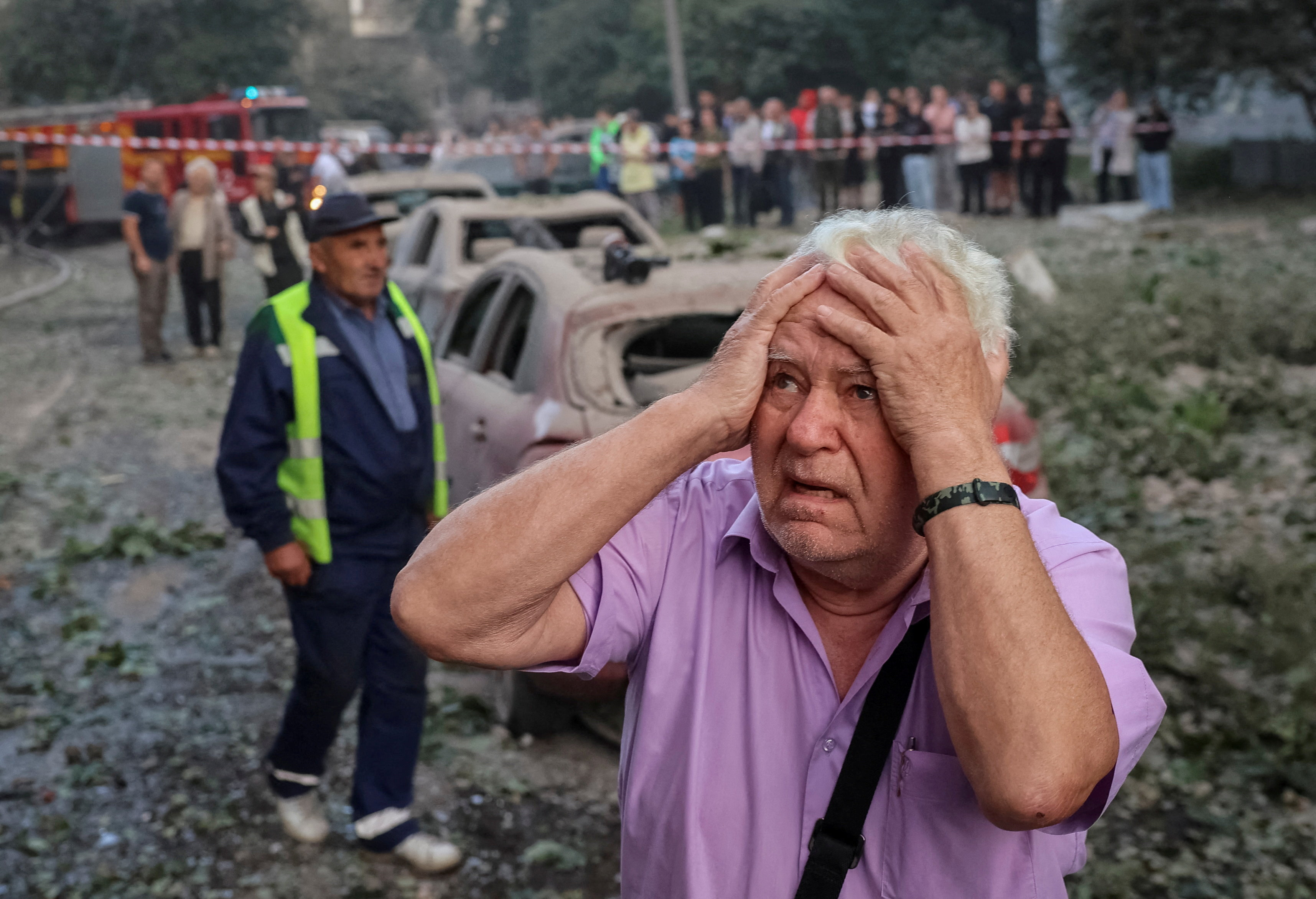 A man reacts near an apartment building.