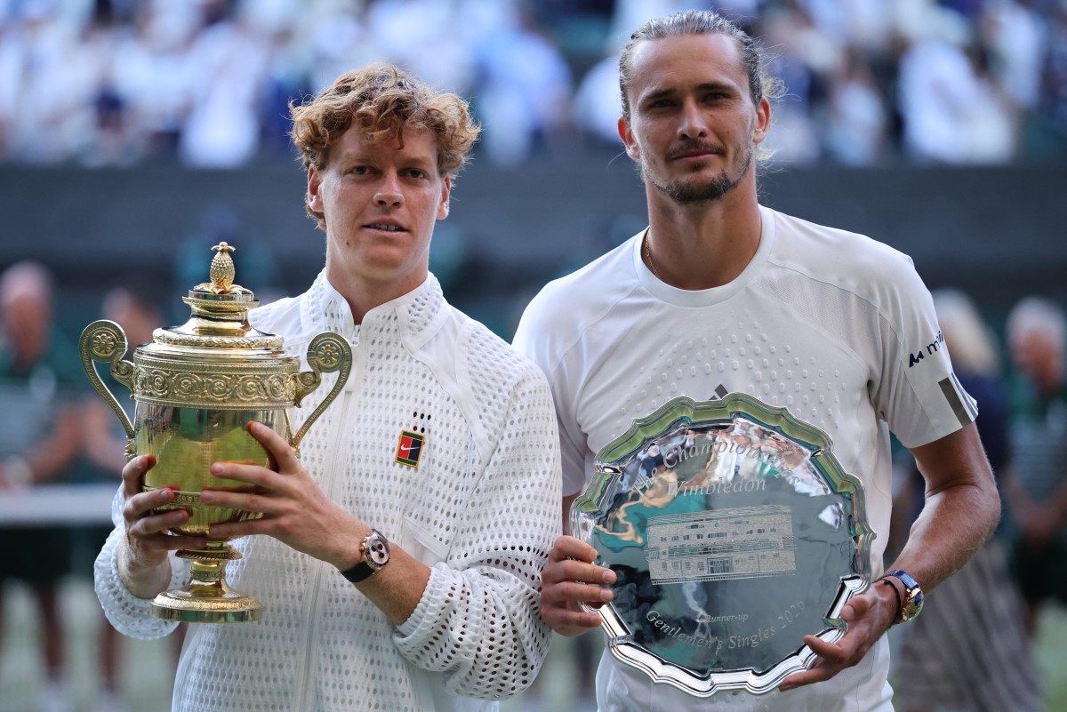 Italy's Jannik Sinner (L) poses with the Gentlemen's Singles Trophy after winning the men's singles final tennis match against Germany's Alexander Zverev