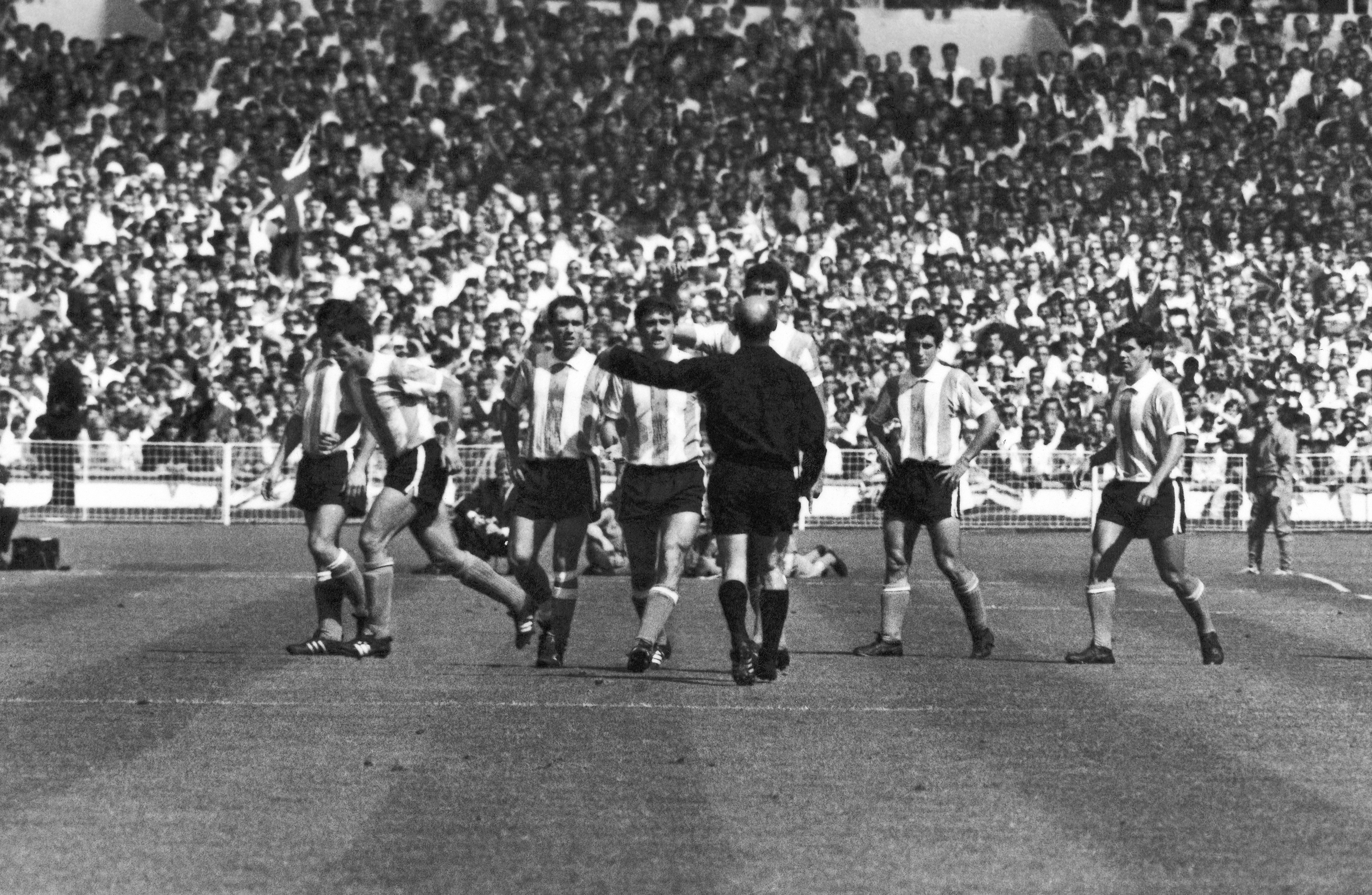 West German referee Rudolf Kreitlein tries to pacify angry Argentine players after sending off teammate Antonio Rattin during the 1966 World Cup quarterfinal