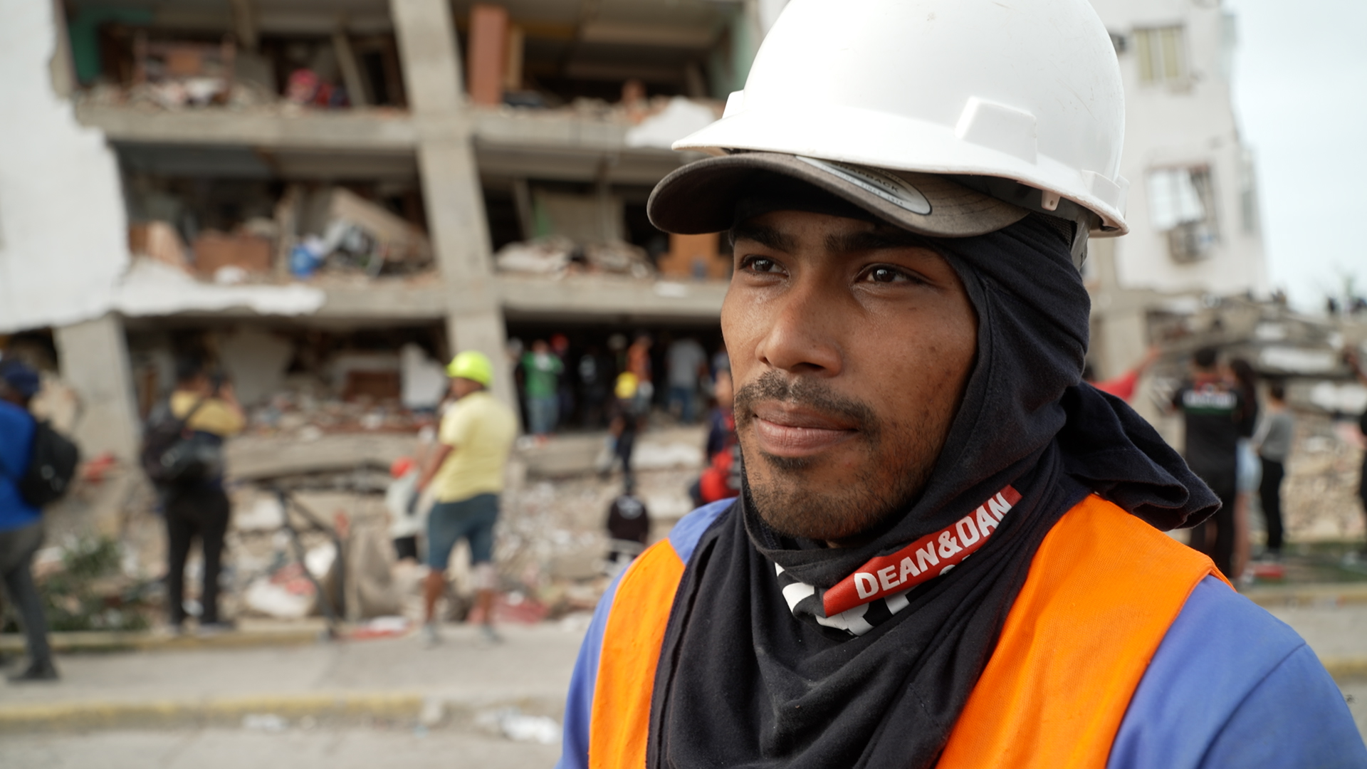 Javier Villegas stands in a hard hat outside a dangerously unstable building in La Guaira, Venezuela