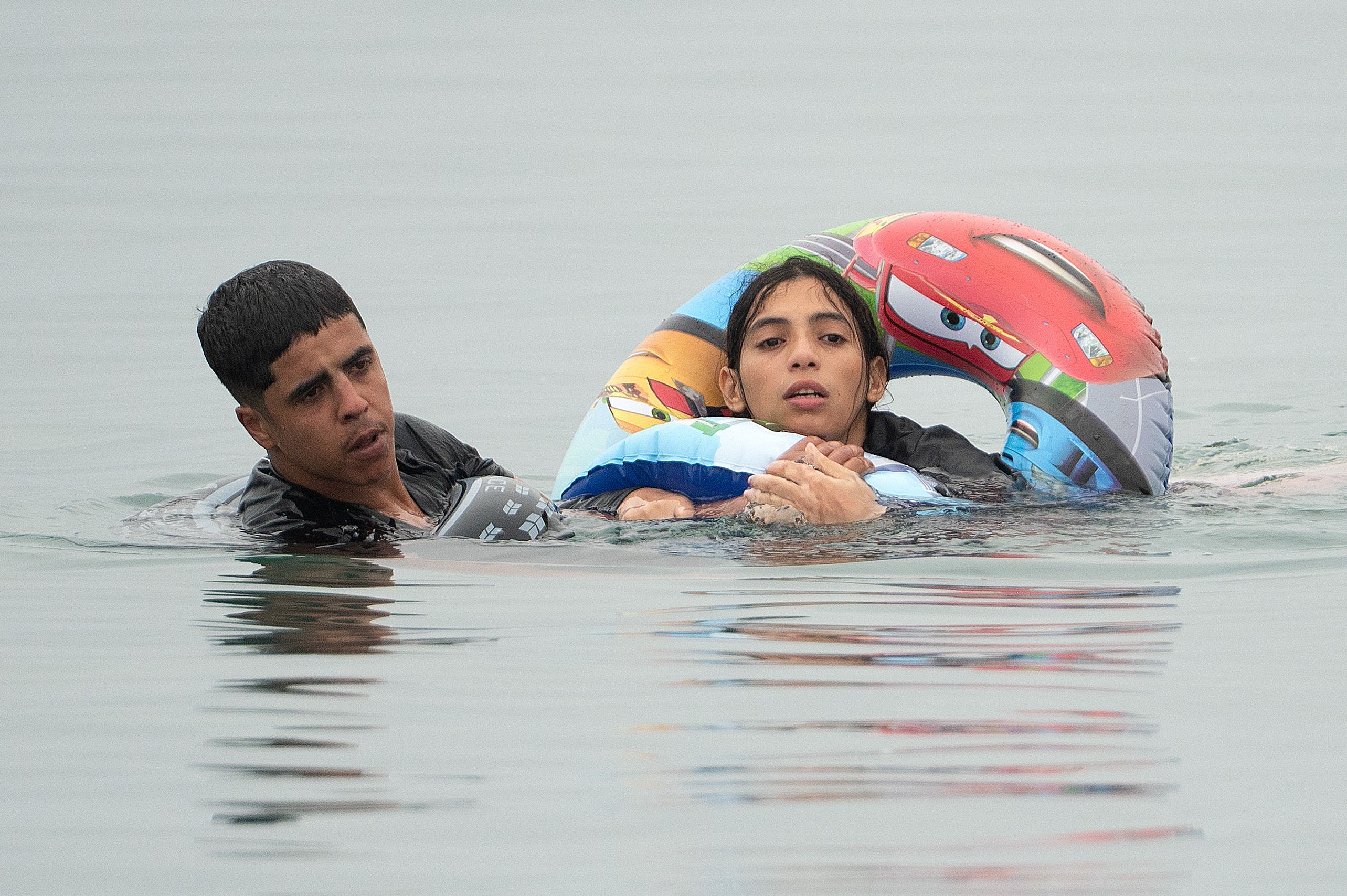TOPSHOT - Migrants swim around a border barrier with Morocco to enter Spain's north Africa's Ceuta enclave on July 31, 2026.