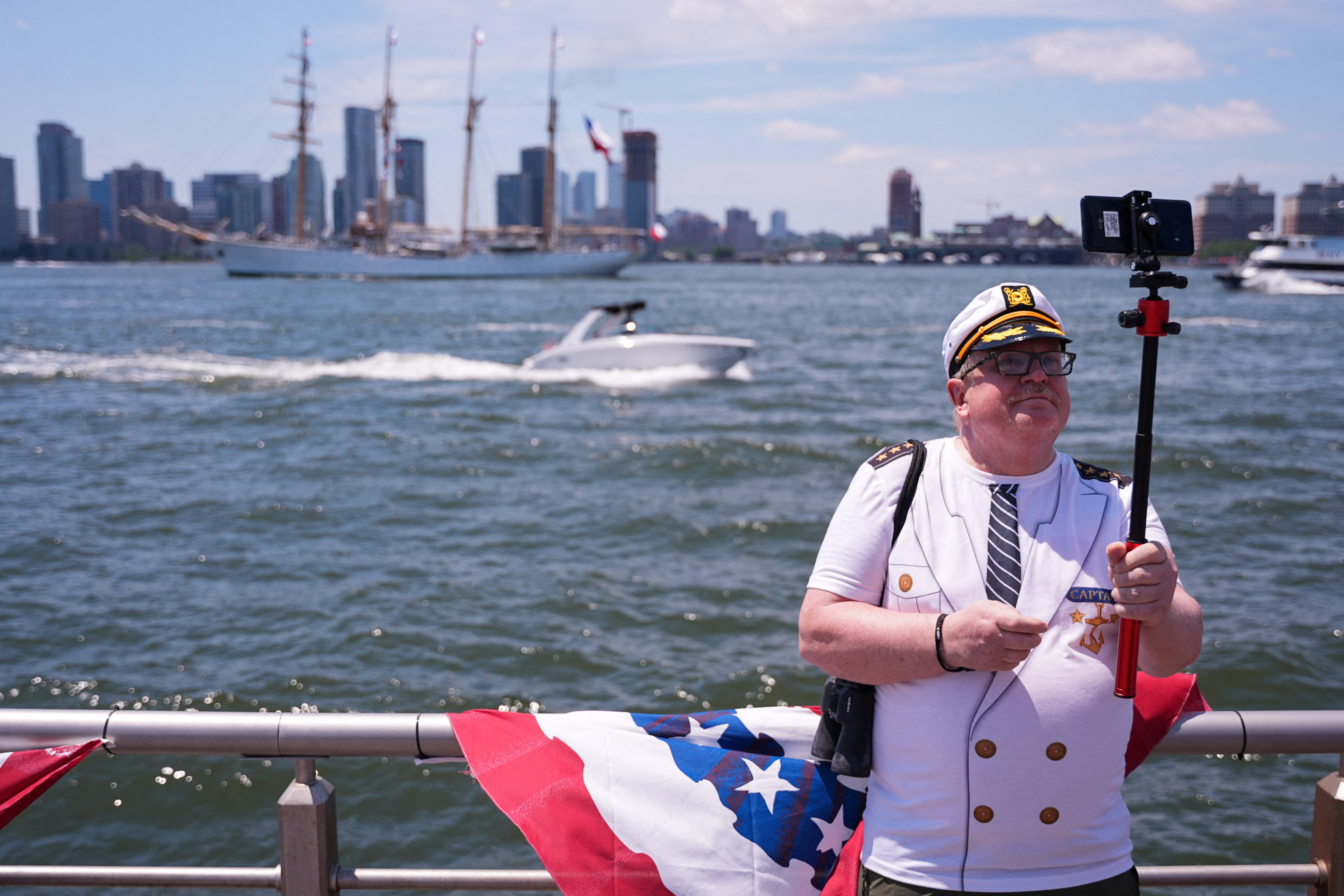 A man in nautical-themed clothing records images as the United States celebrates its 250th anniversary on Independence Day in New York City, U.S., July 4, 2026. REUTERS/Angelina Katsanis