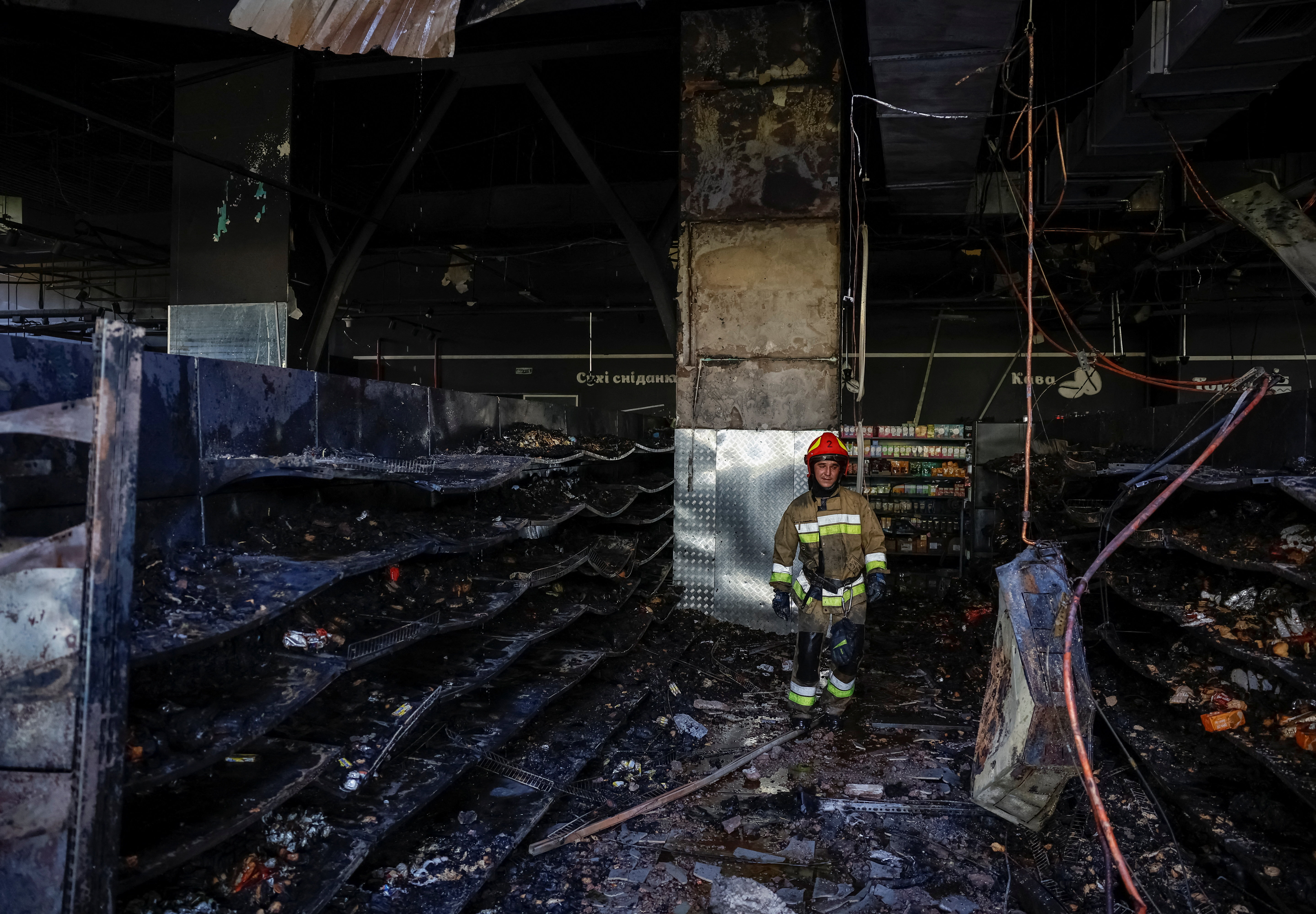 A Ukrainian firefighter inspects the site of a supermarket in Chernihiv that was hit by a Russian drone. [REUTERS/Maksym Kishka]