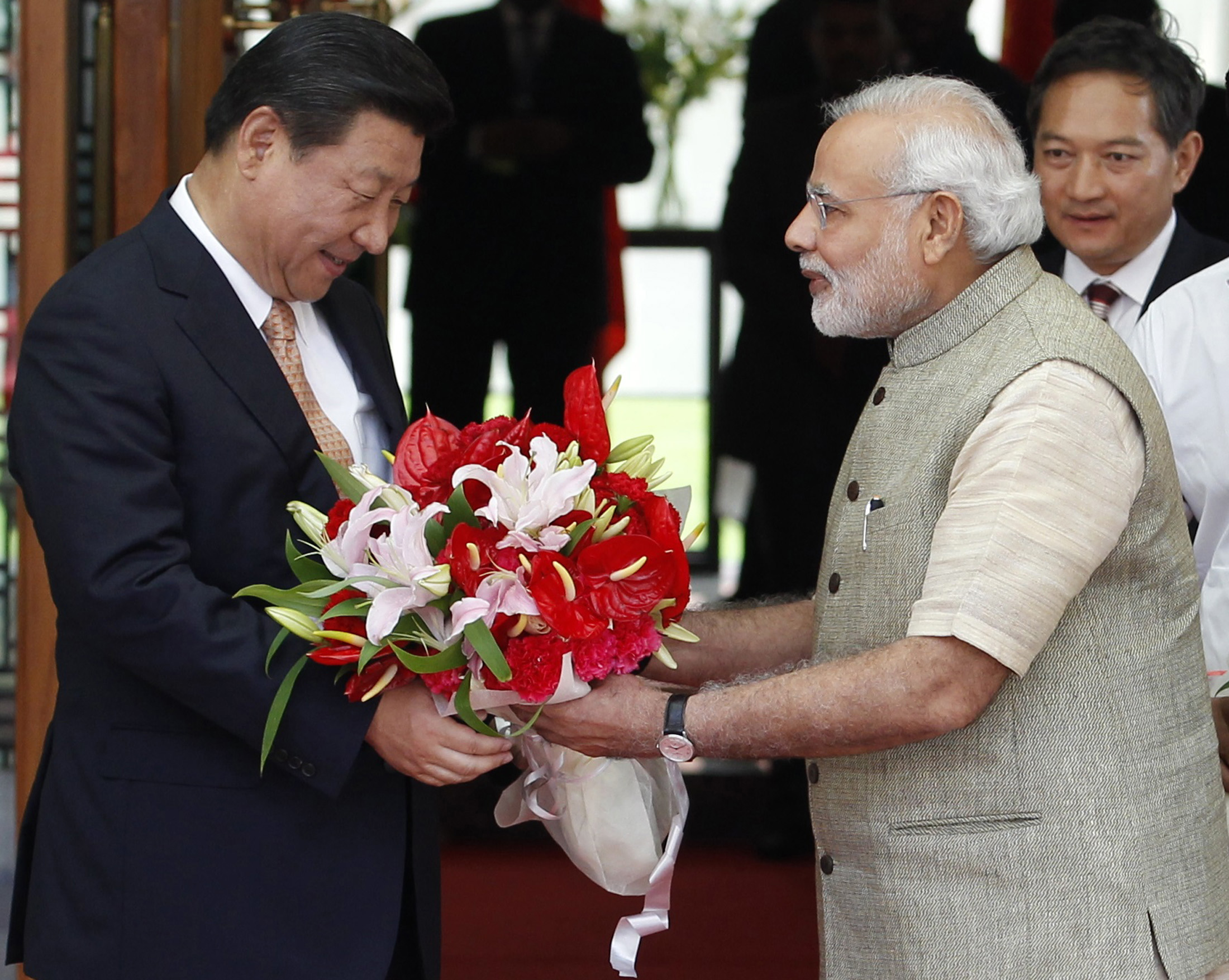 India’s Prime Minister Narendra Modi presents a bouquet to China’s President Xi Jinping before their meeting in the western Indian city of Ahmedabad, on September 17, 2014