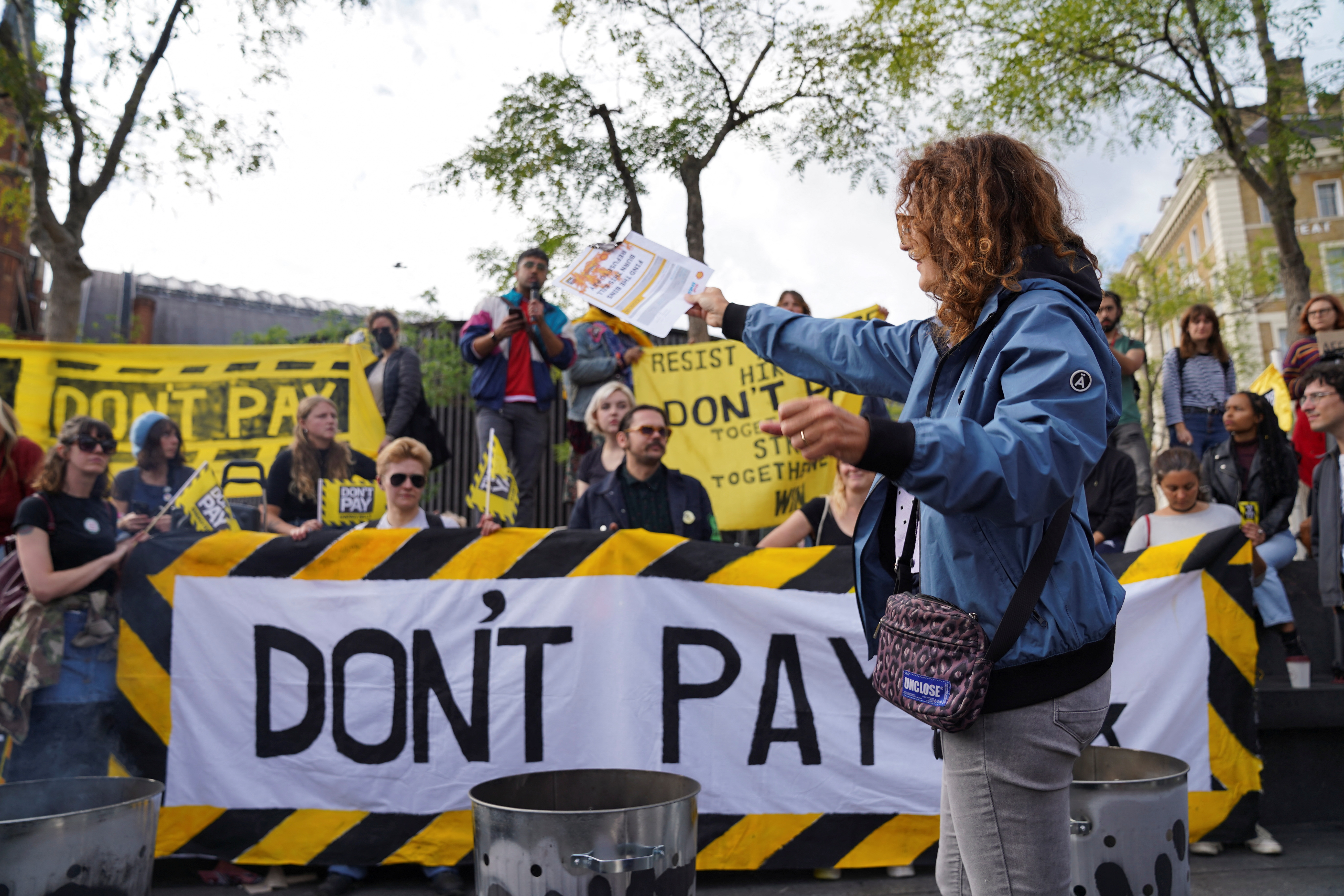A volunteer burns a bill in the protest against raising costs of living, at Kings Cross in London, Britain October 1, 2022. REUTERS/Maja Smiejkowska