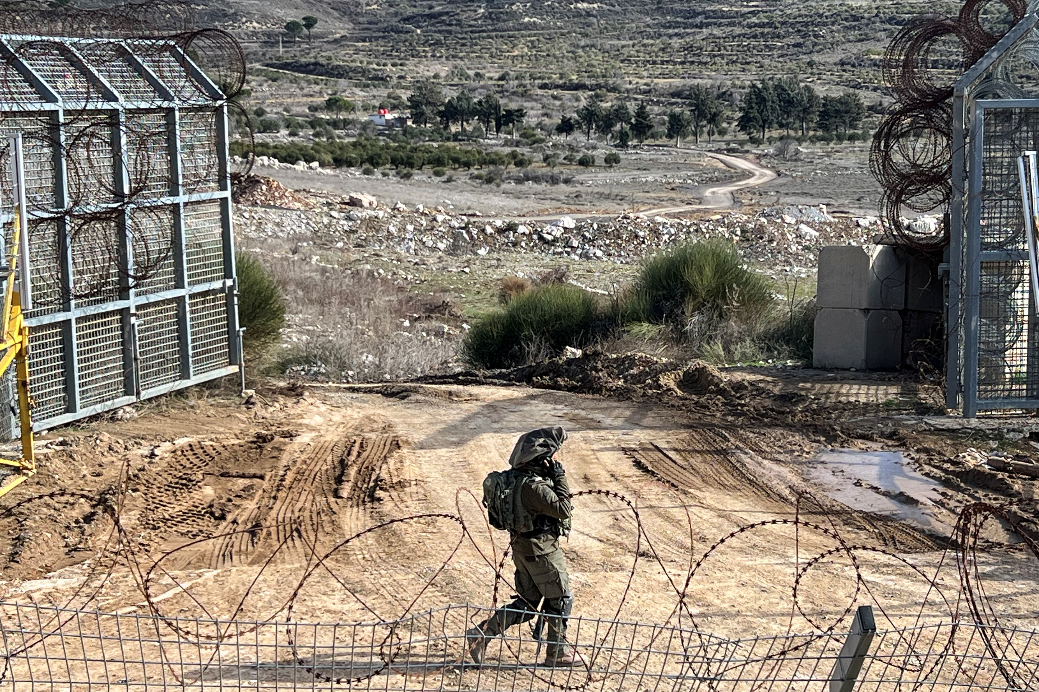 An Israeli soldier walks by the ceasefire line with Syria and the Israeli-occupied Golan Heights
