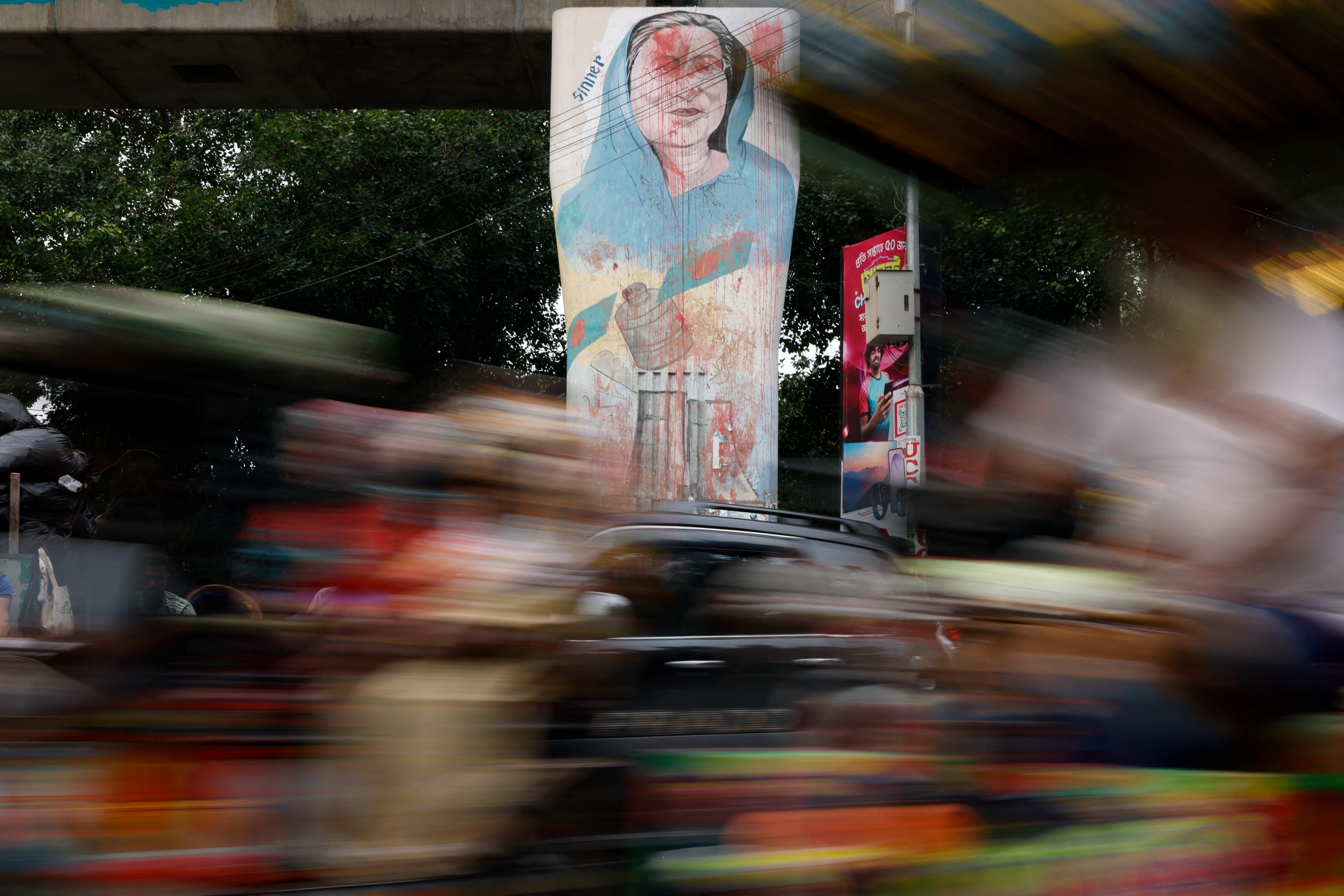 Vehicles move past a mural of Bangladesh’s ousted Prime Minister Sheikh Hasina, at the University of Dhaka, in Dhaka, Bangladesh, June 29, 2026