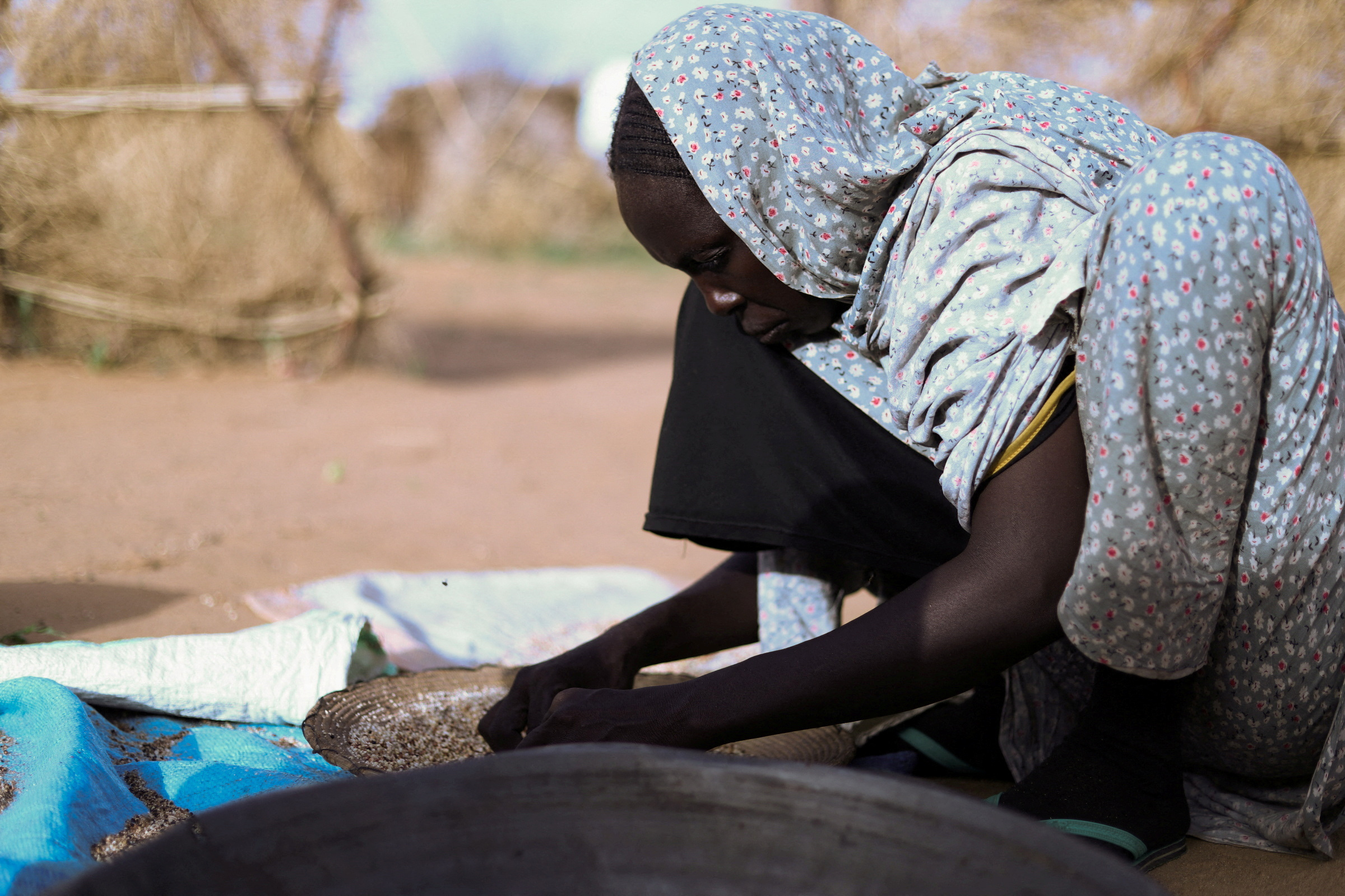 Displaced Sudanese mother of five Hanan Adam Hassan prepares food at a camp shelter in Tawila, North Darfur.[File: Reuters]