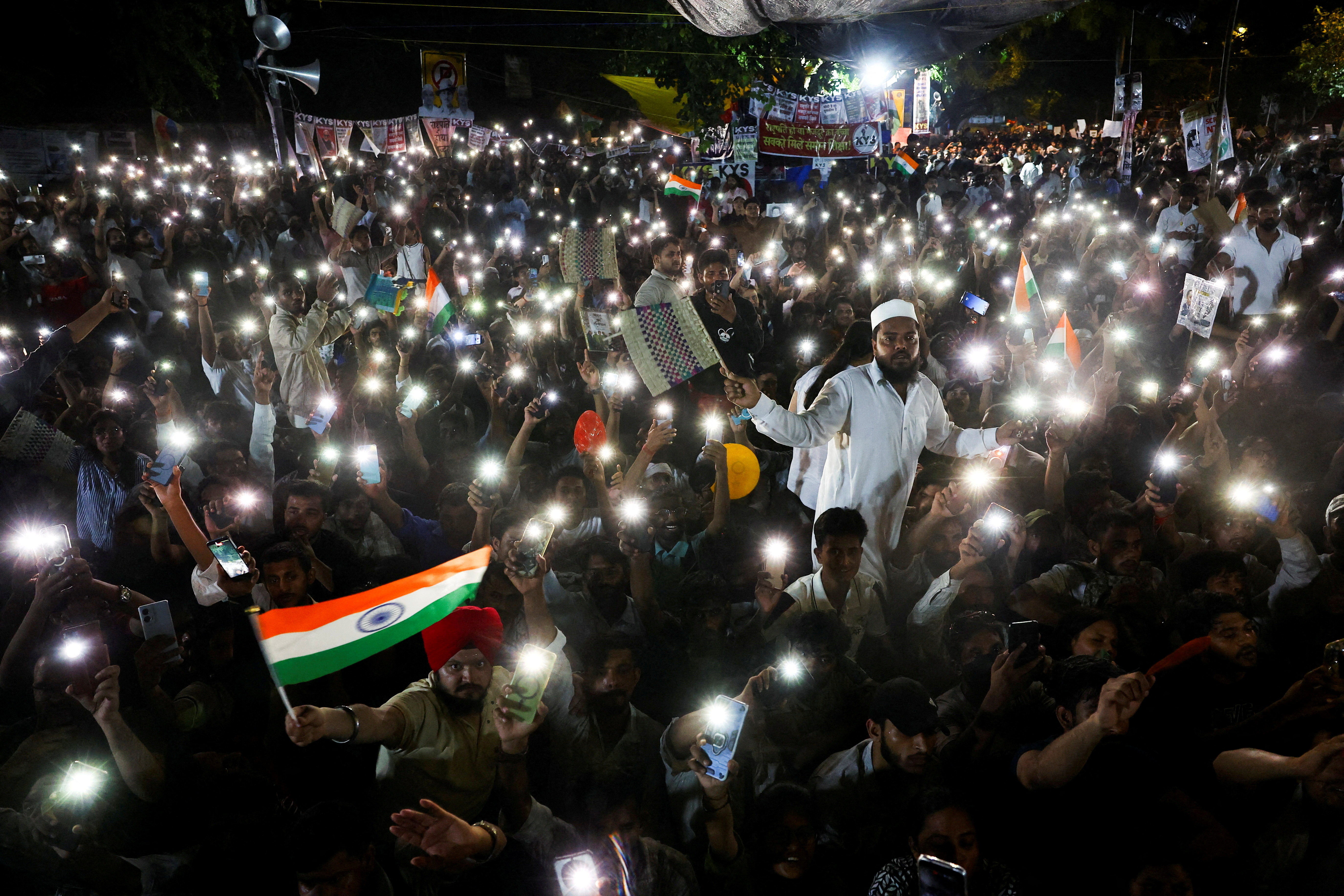 Supporters of the Cockroach Janta Party (CJP) chant slogans and wave their mobile phones with their flashlights on as they gather during a sit-in protest demanding the resignation of Indian Education Minister Dharmendra Pradhan, at Jantar Mantar in New Delhi, India, on July 19, 2026