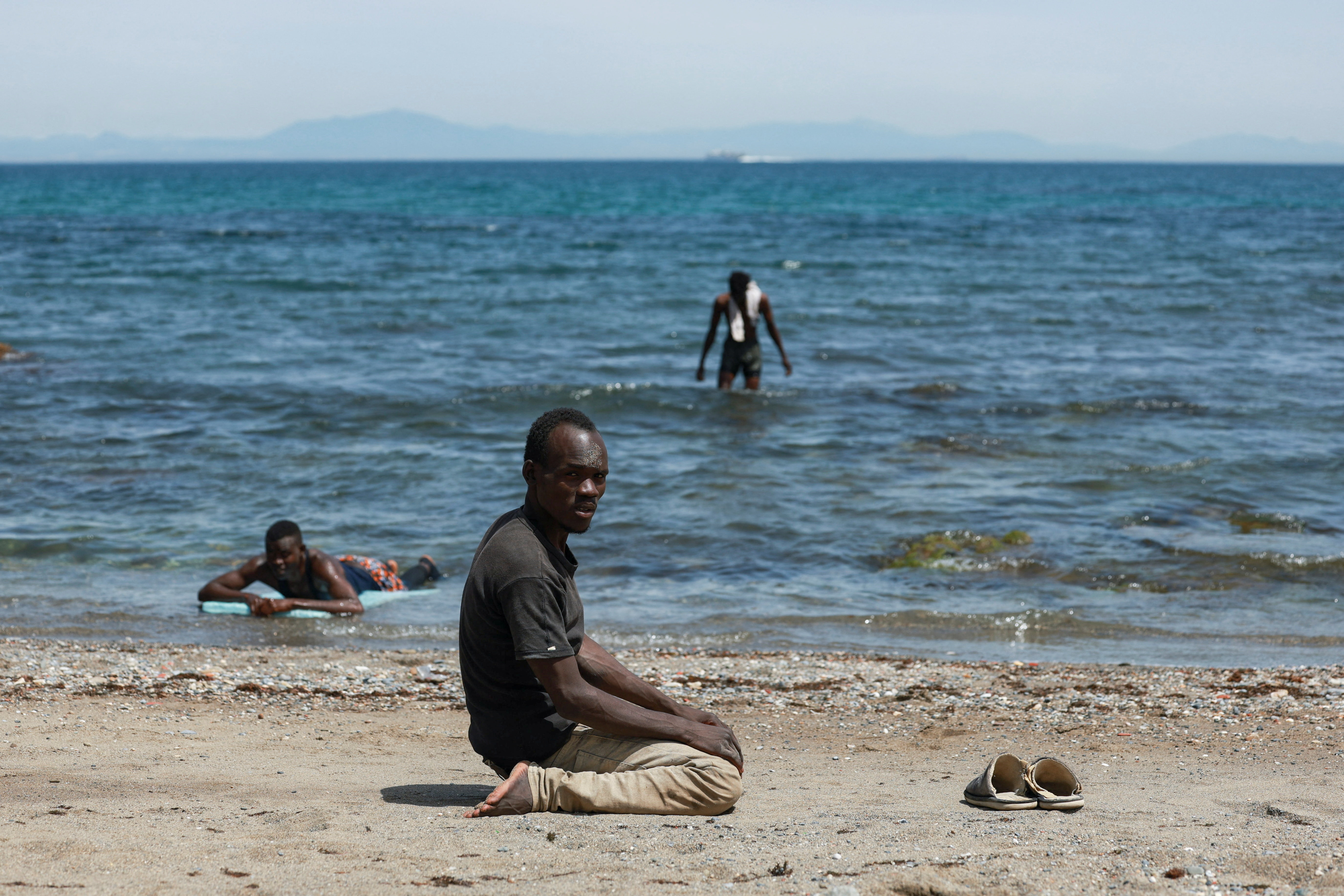A migrant waits on the beach following mass crossings of migrants on foot and by sea from Morocco into Spanish territory in Ceuta, Spain, on August 3, 2026