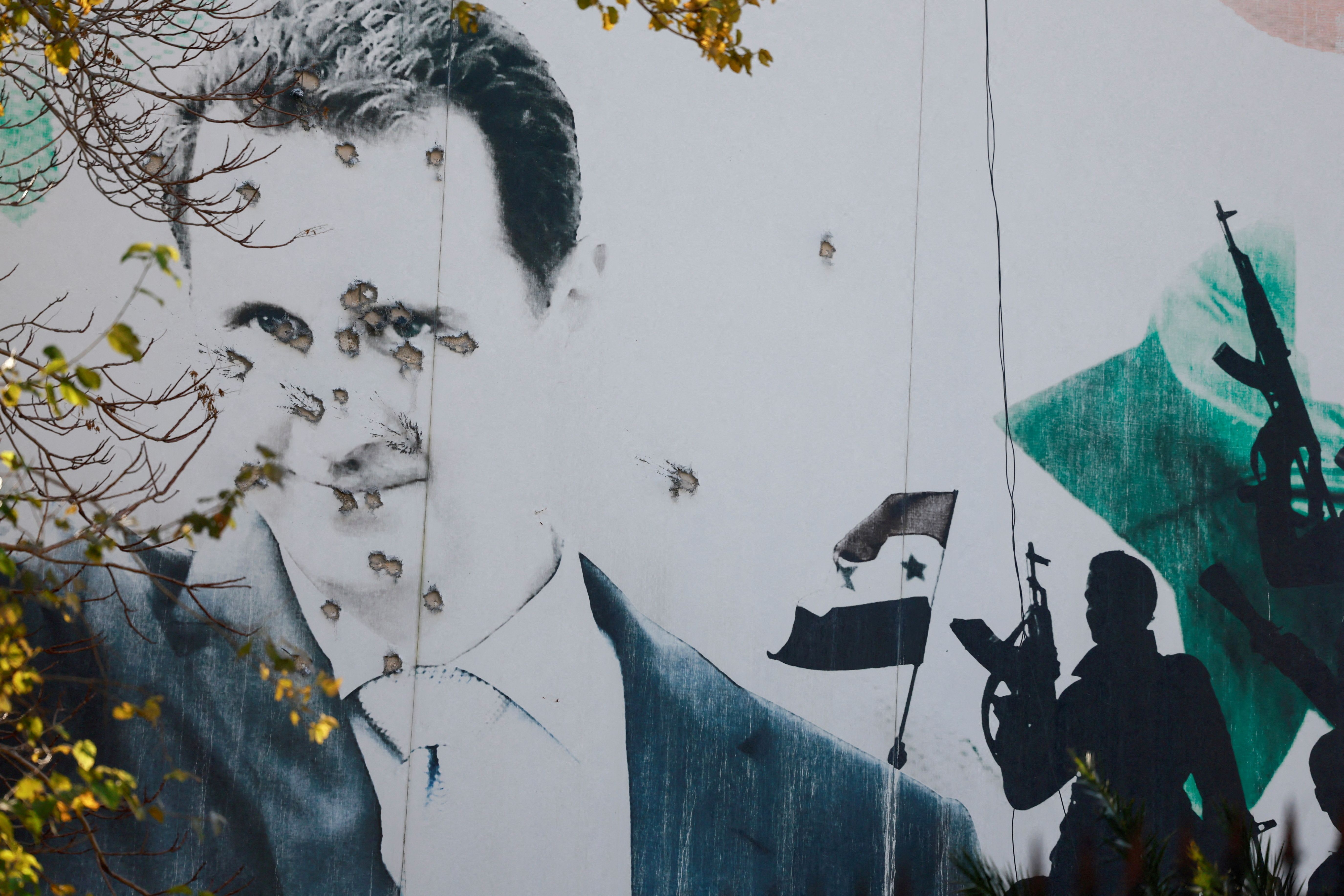 A billboard with a picture of Syria's Bashar al-Assad shows damage by bullet holes, after the ousting of Syria's Bashar al-Assad, in Damascus, Syria, [File: Ammar Awad/Reuters]