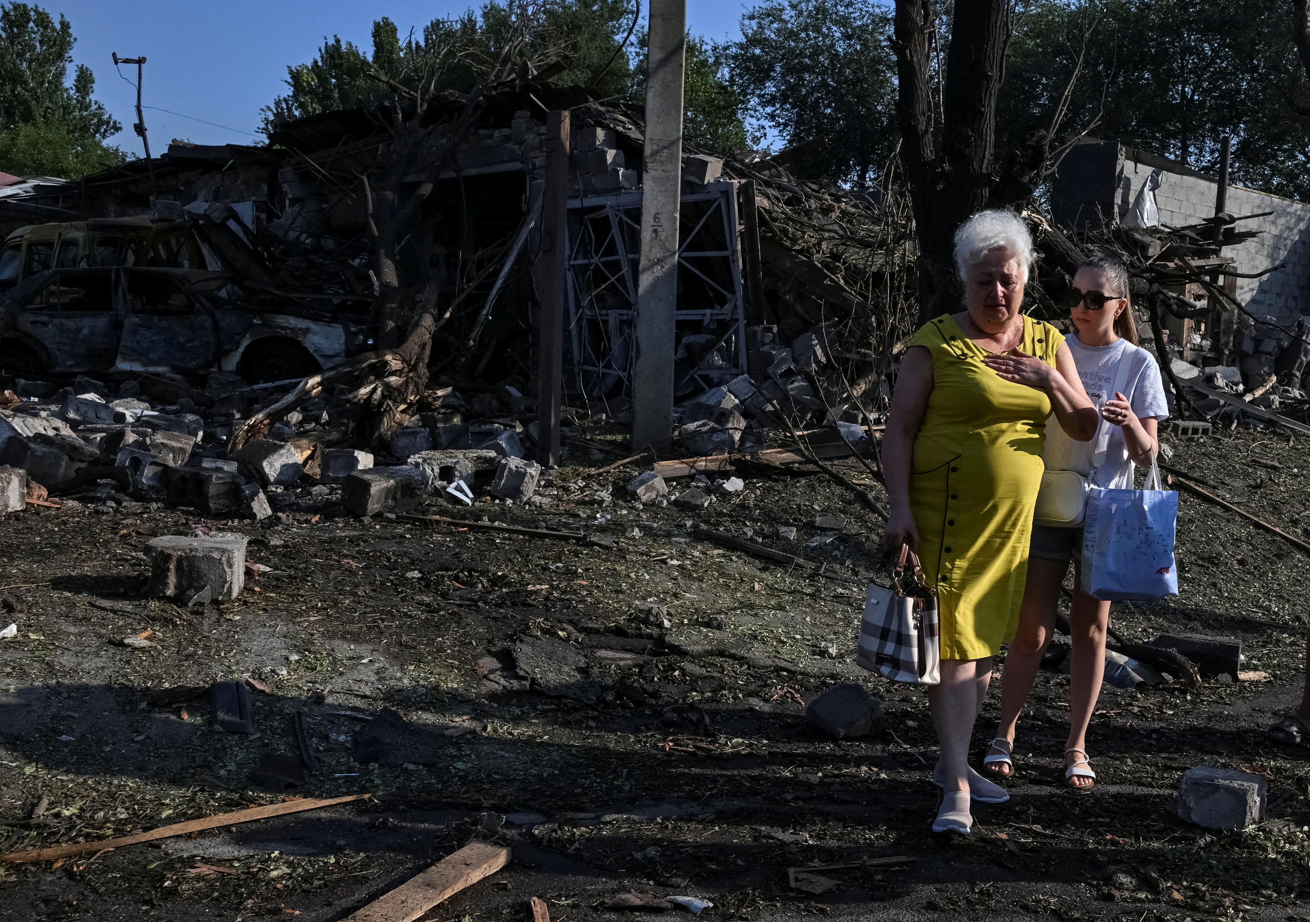 Residents stand at a site of a Russian missile and air strike, amid Russia's attack on Ukraine, in Zaporizhzhia, Ukraine August 11, 2026. REUTERS/Stringer TPX IMAGES OF THE DAY