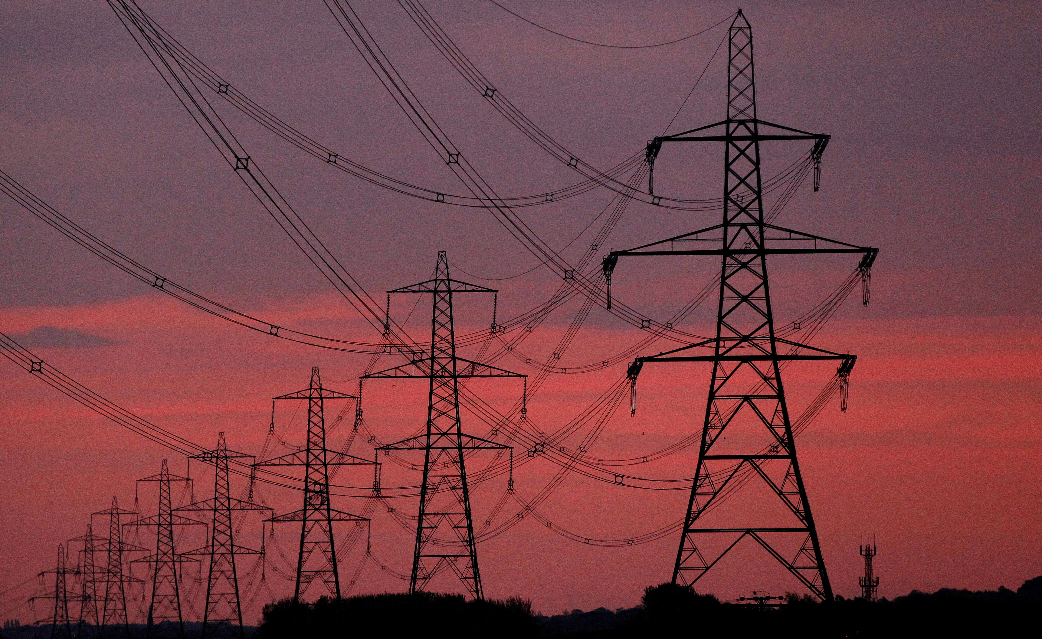 FILE PHOTO: FILE PHOTO: The sun rises behind electricity pylons near Chester, northern England October 24, 2011. REUTERS/Phil Noble/File Photo