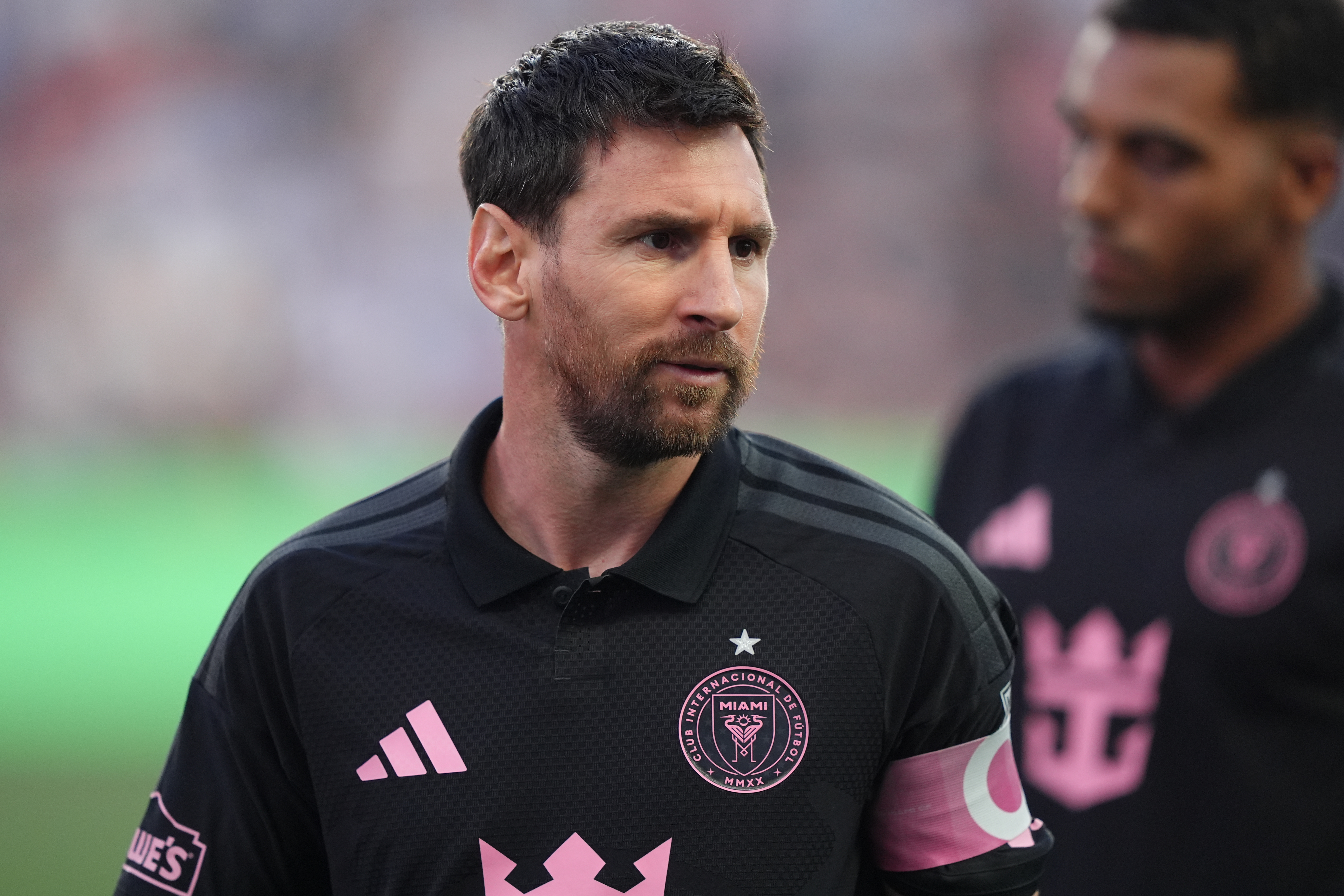 A football player stands on the pitch.