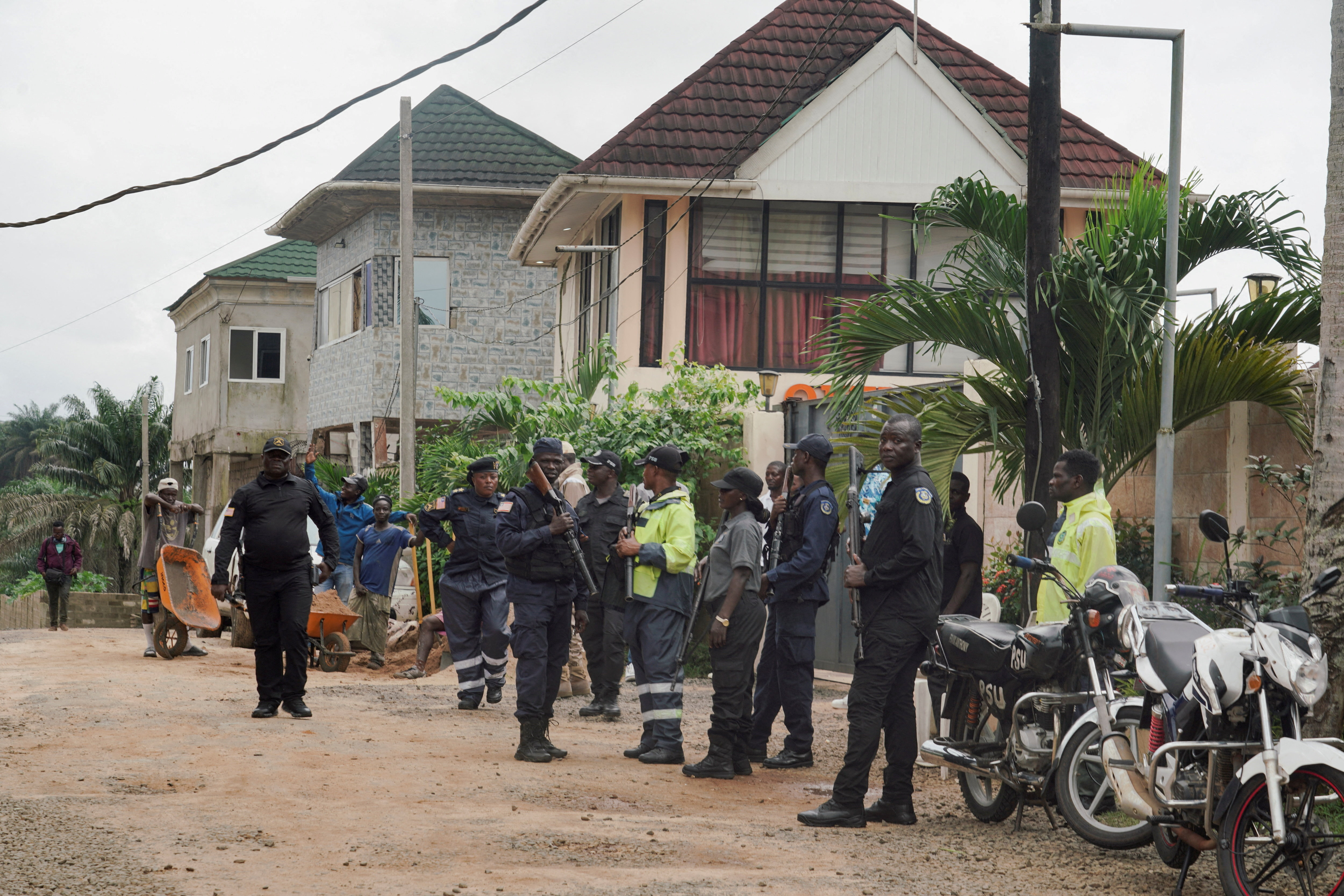 Security guards stand outside a building in Marshall, a small beach town near Roberts International Airport, as deportees from the United States arrive in Liberia, August 20, 2026