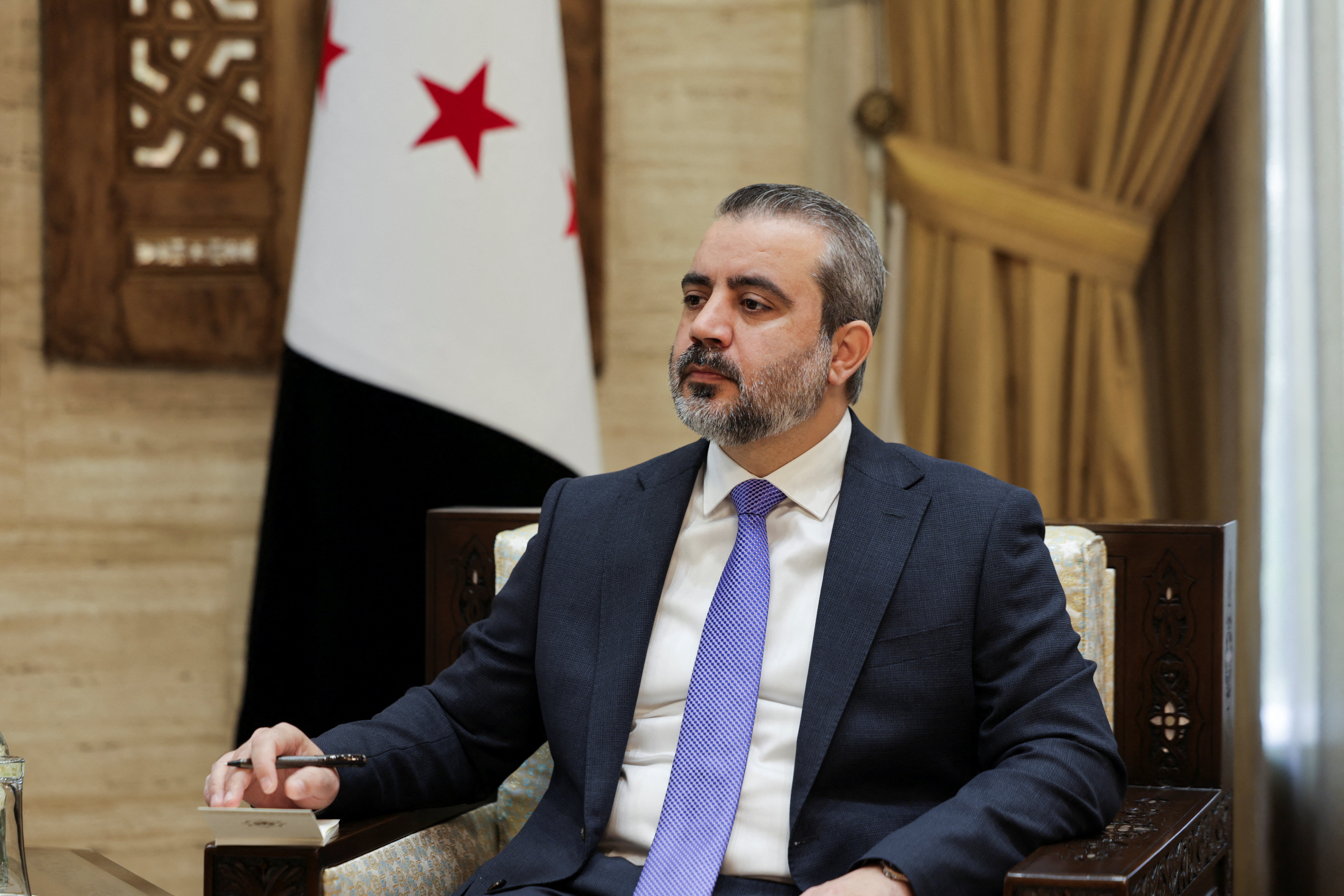 Syrian Foreign Minister Asaad al-Shaibani looks on during an interview with Reuters in Damascus, Syria [Khalil Ashawi/Reuters]