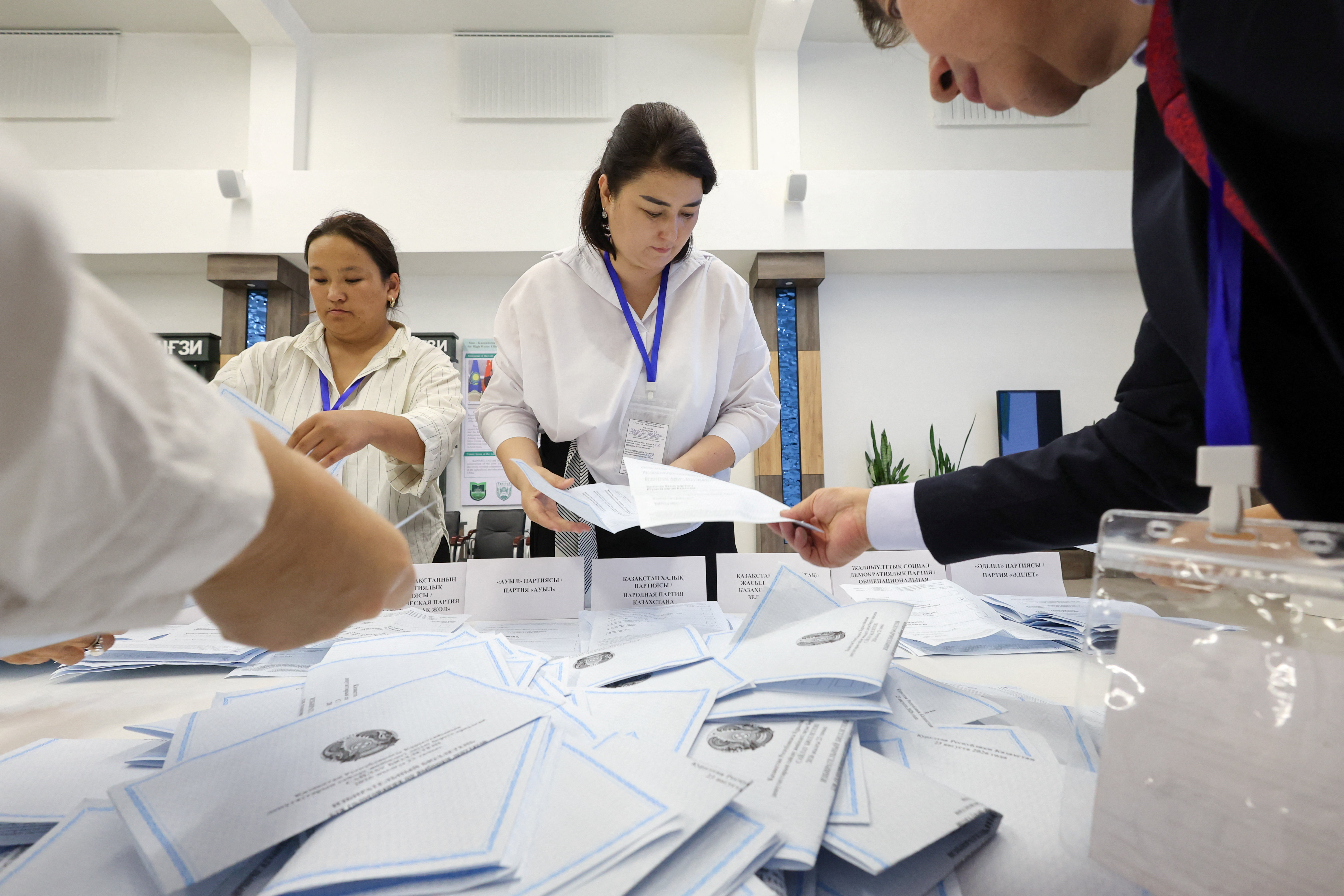 Members of Kazakh electoral commission count votes after polling stations closed on the day of a parliamentary election in Almaty, Kazakhstan. [Pavel Mikheyev/Reuters]