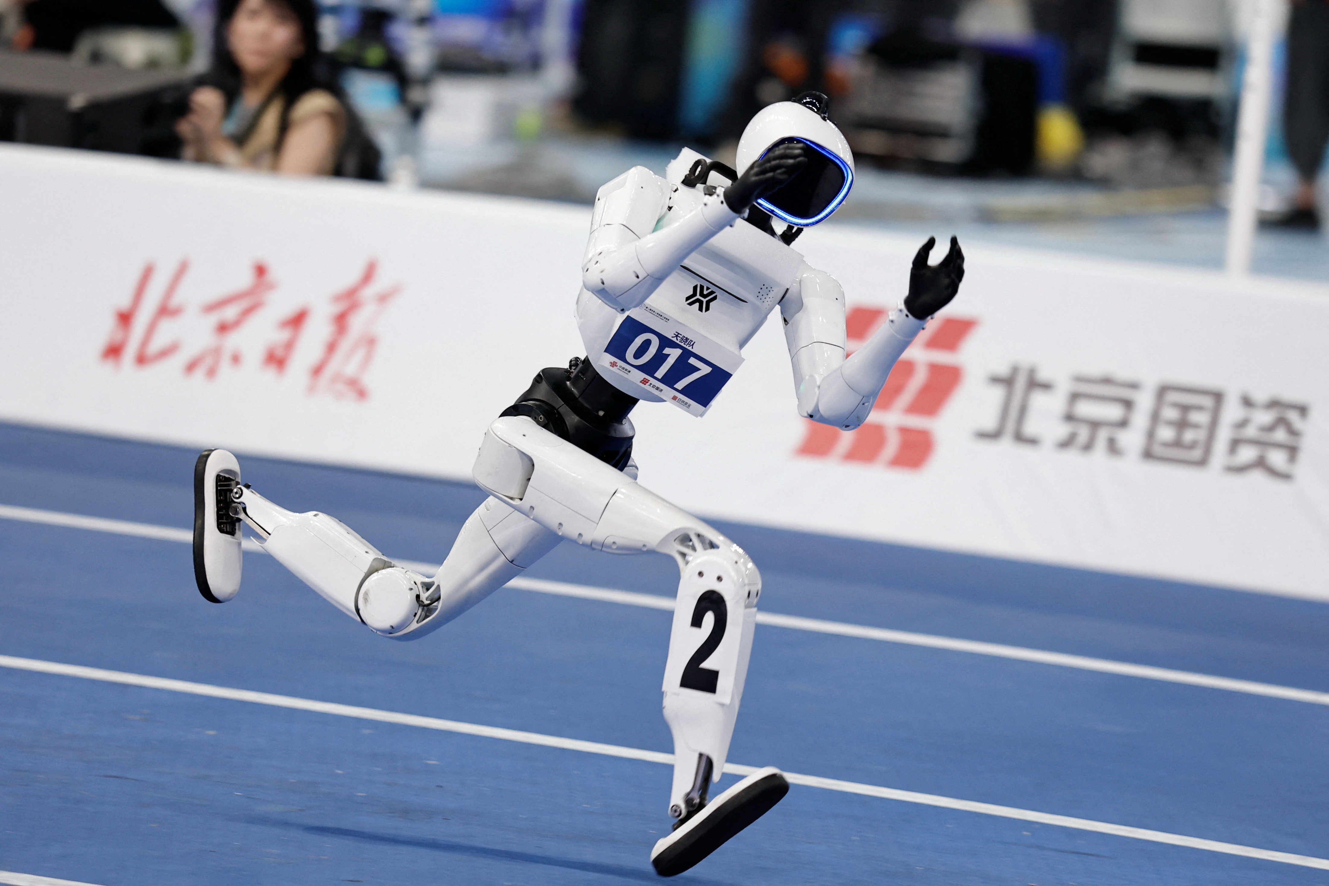 A Tiangong Omni humanoid robot competes during a 100m small-size group preliminary race, at the 2026 World Humanoid Robot Games