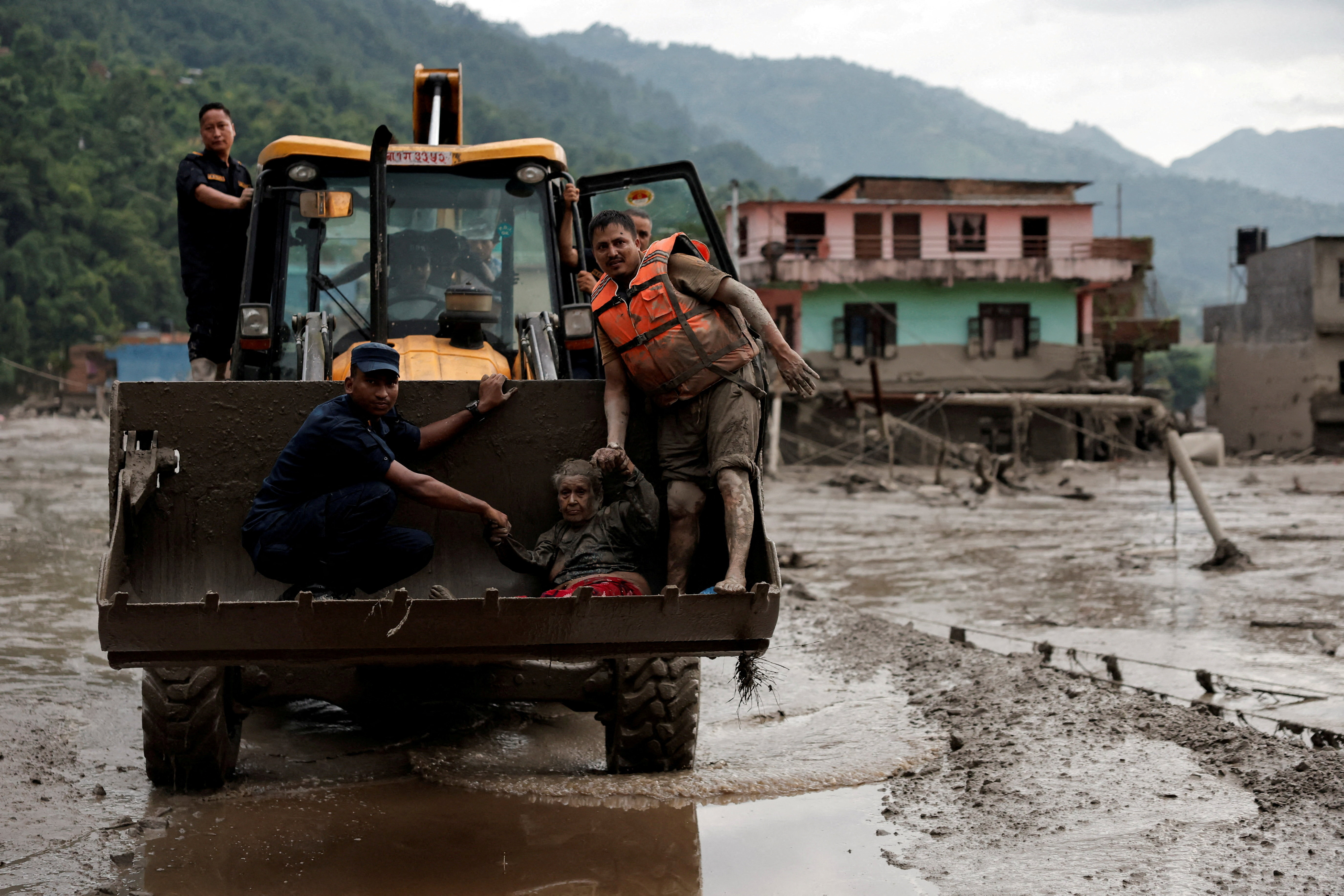 A survivor is transported to a safer place in heavy machinery following a flash flood at Trishuli in Nuwakot district, Nepa