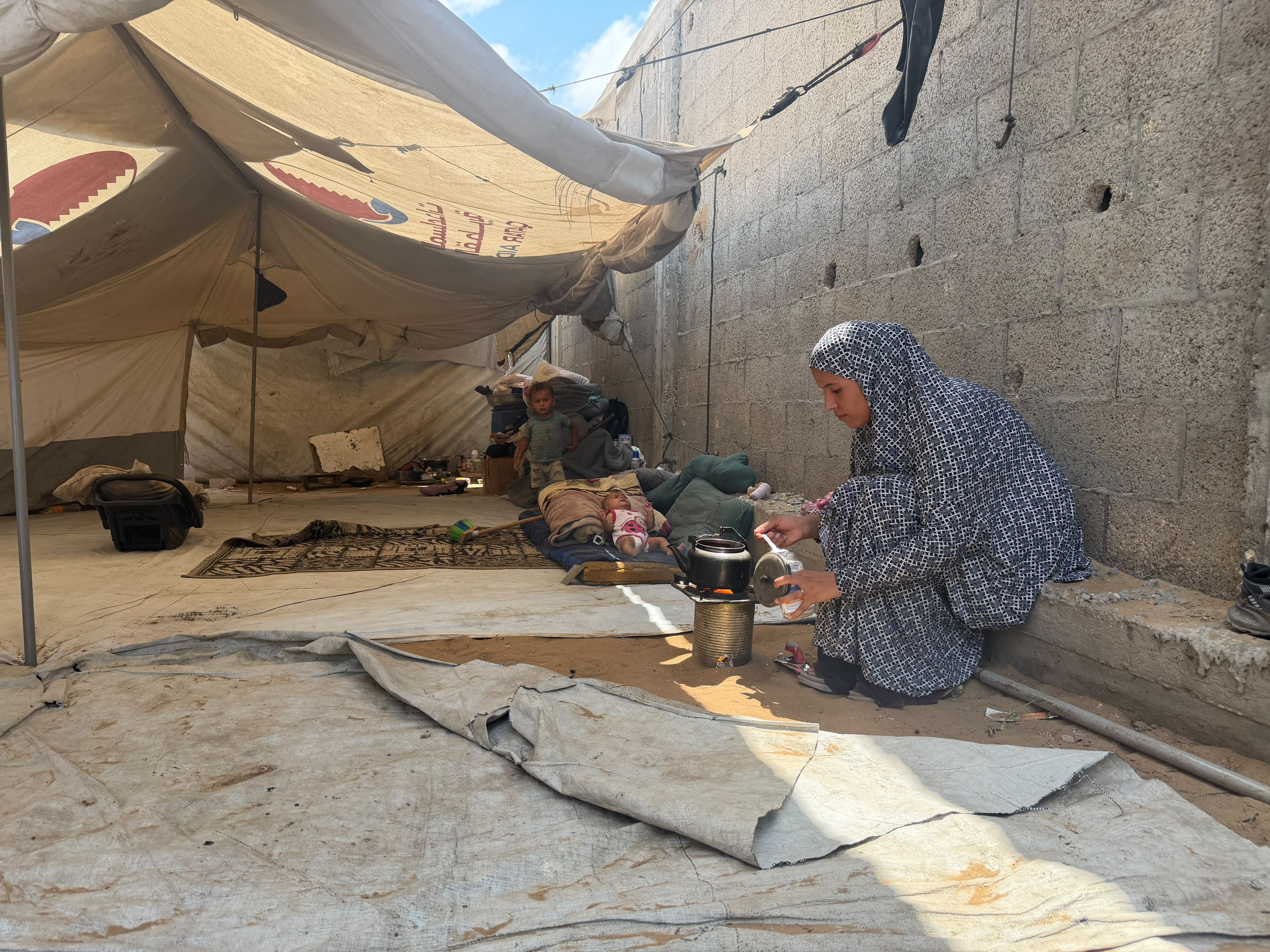 Al-Sahwi family make food in their tent [Hashem Zimmo/Al Jazeera]