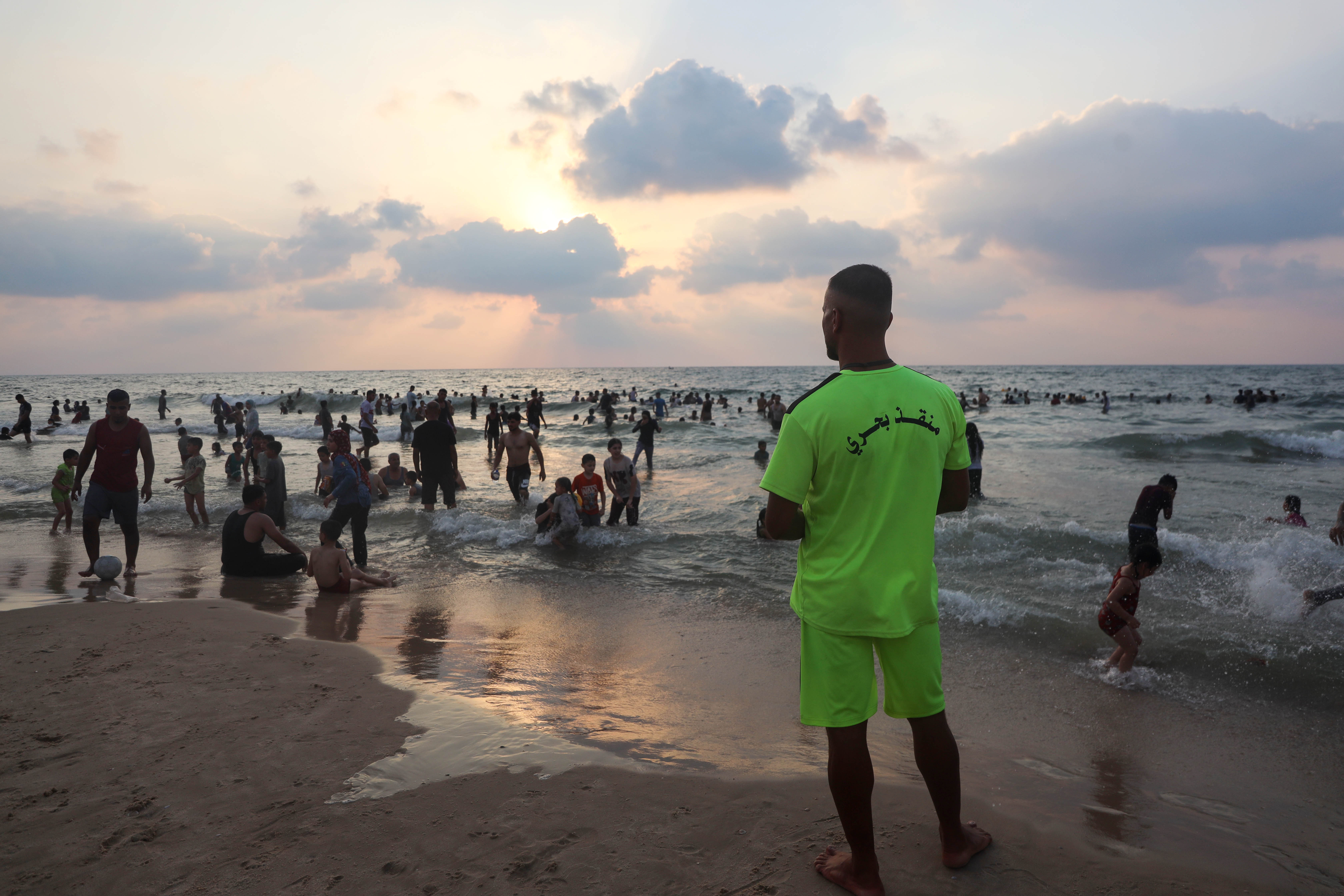 Gaza’s lifeguards monitor swimmers along the coast as Palestinians flock to the sea during summer to escape the heat in tents [Abdelhakim Abu Riash/ Al Jazeera]